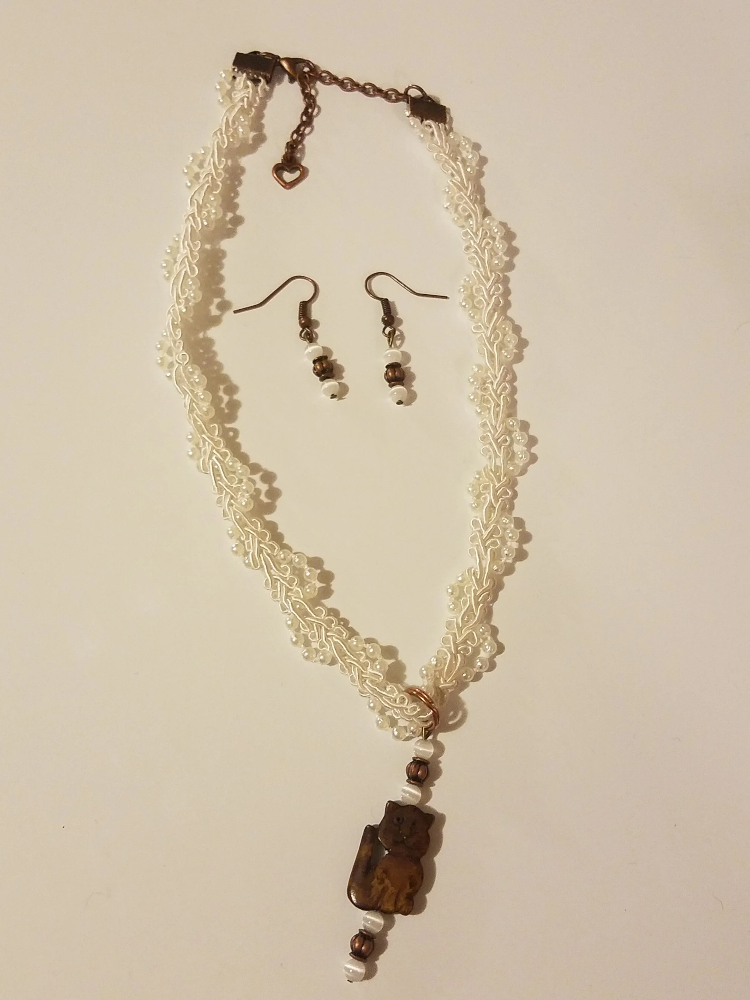 Jewelry set consisting of a necklace and matching earrings, with a bear-shaped pendant on the necklace.