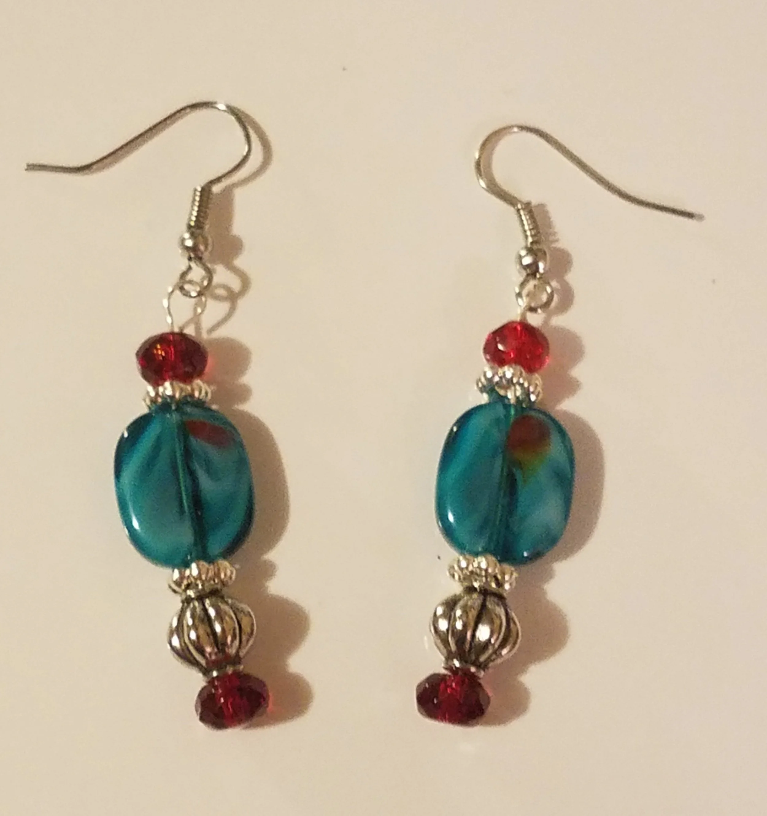 Pair of colorful dangle earrings with blue and red beads and silver accents.