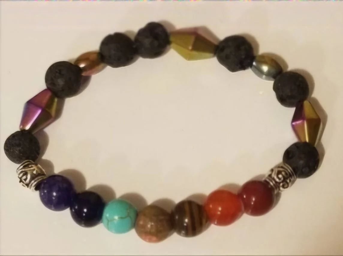Beaded bracelet with multicolored stones and metallic beads, arranged in a circular shape.