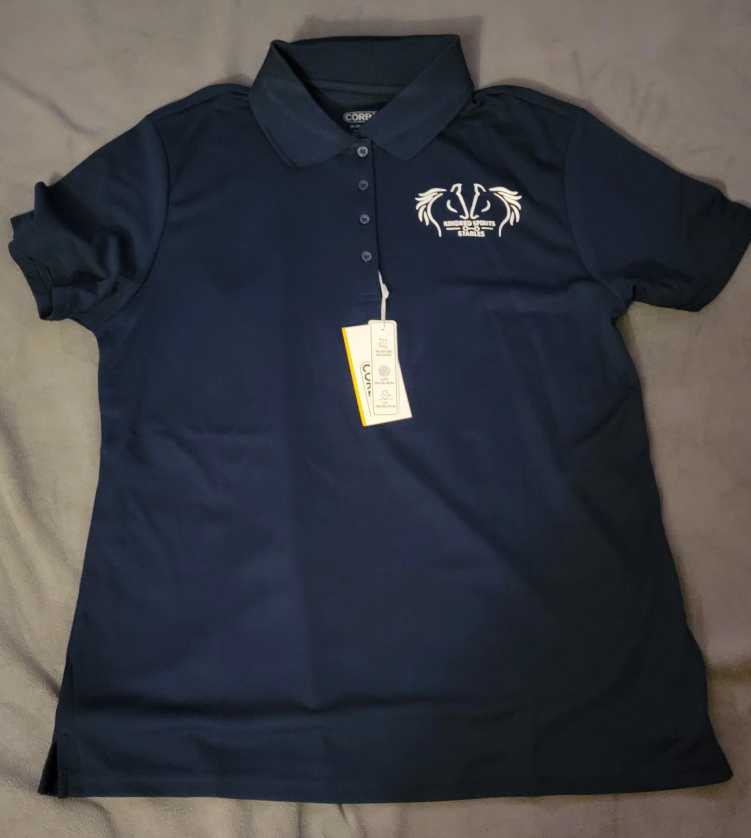 Navy blue polo shirt with a logo on the left chest area featuring two stylized horse heads and the text 'Hundred Springs Stallions'.