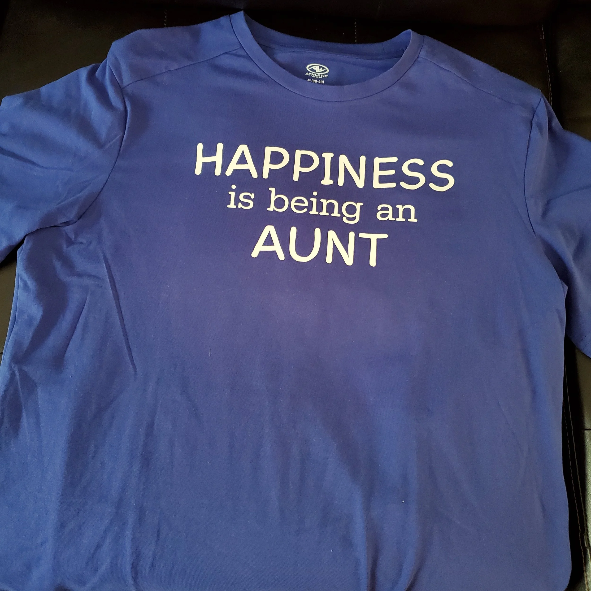 Blue T-shirt with white text that reads 'HAPPINESS is being an AUNT'.