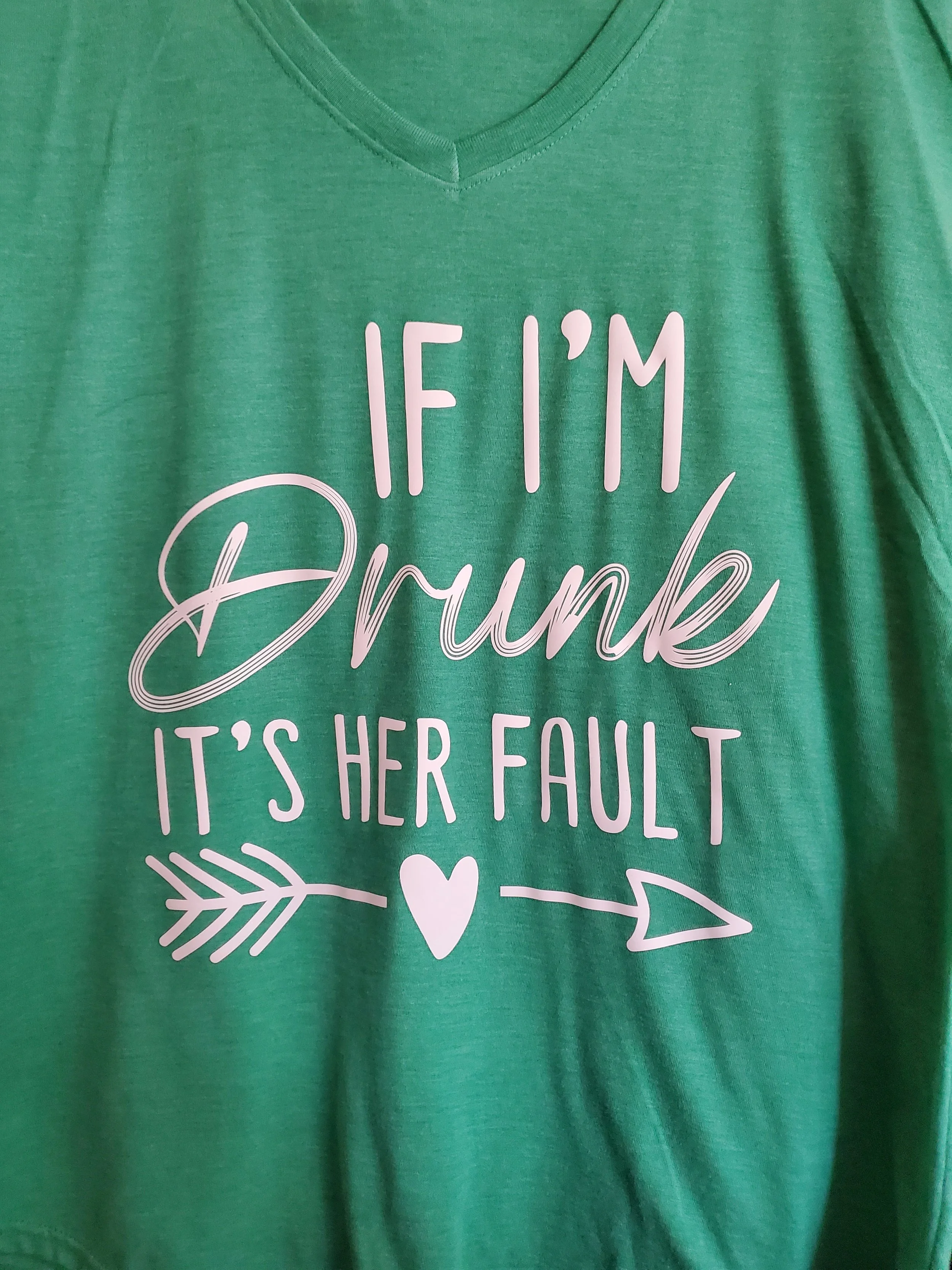 Green T-shirt with white text that reads 'If I'm Drunk, It's Her Fault' and has a decorative arrow with a heart in the middle.