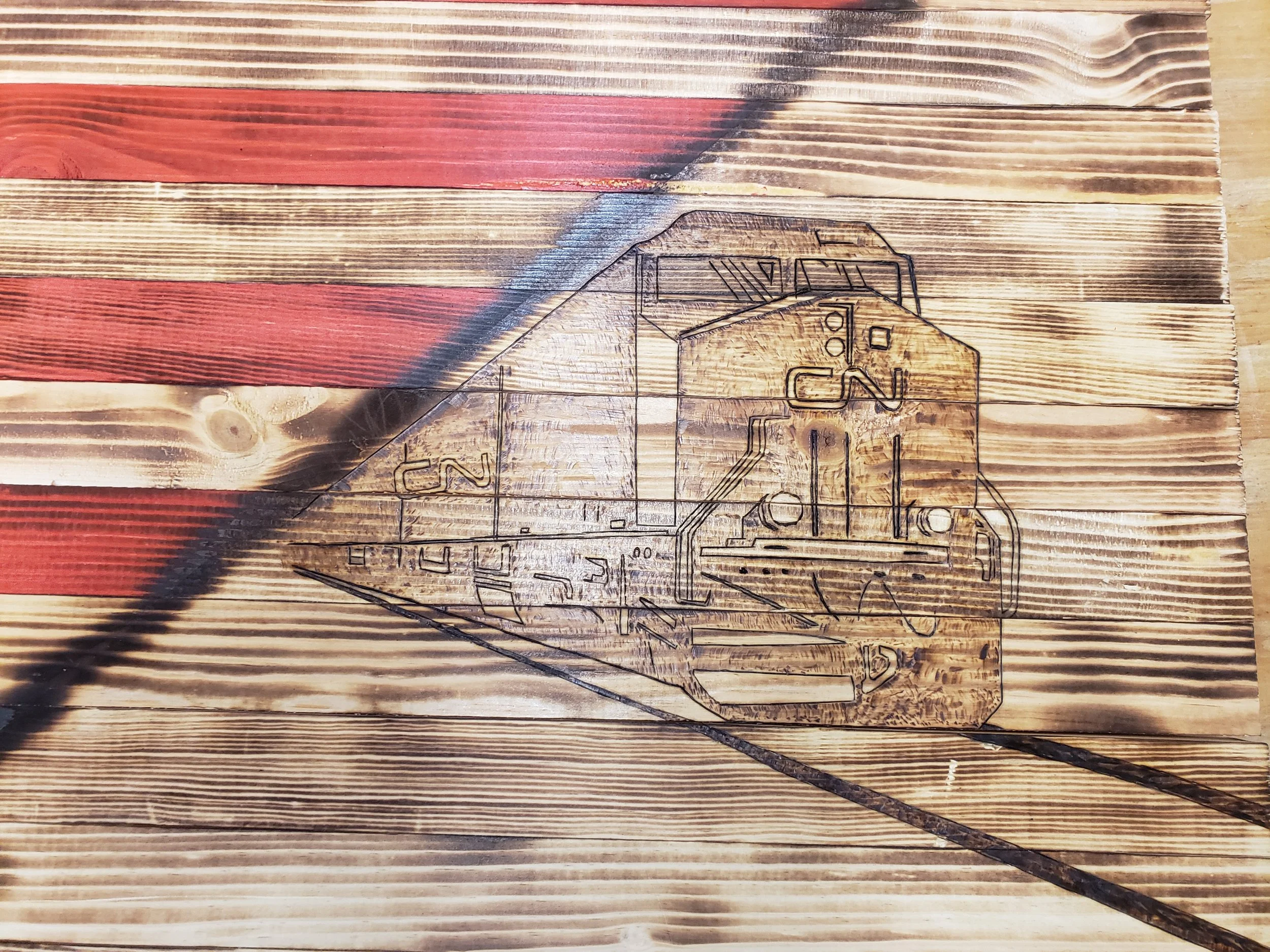 Design of a vintage train engraved on a wood plank, with red and natural wood tones in the background.
