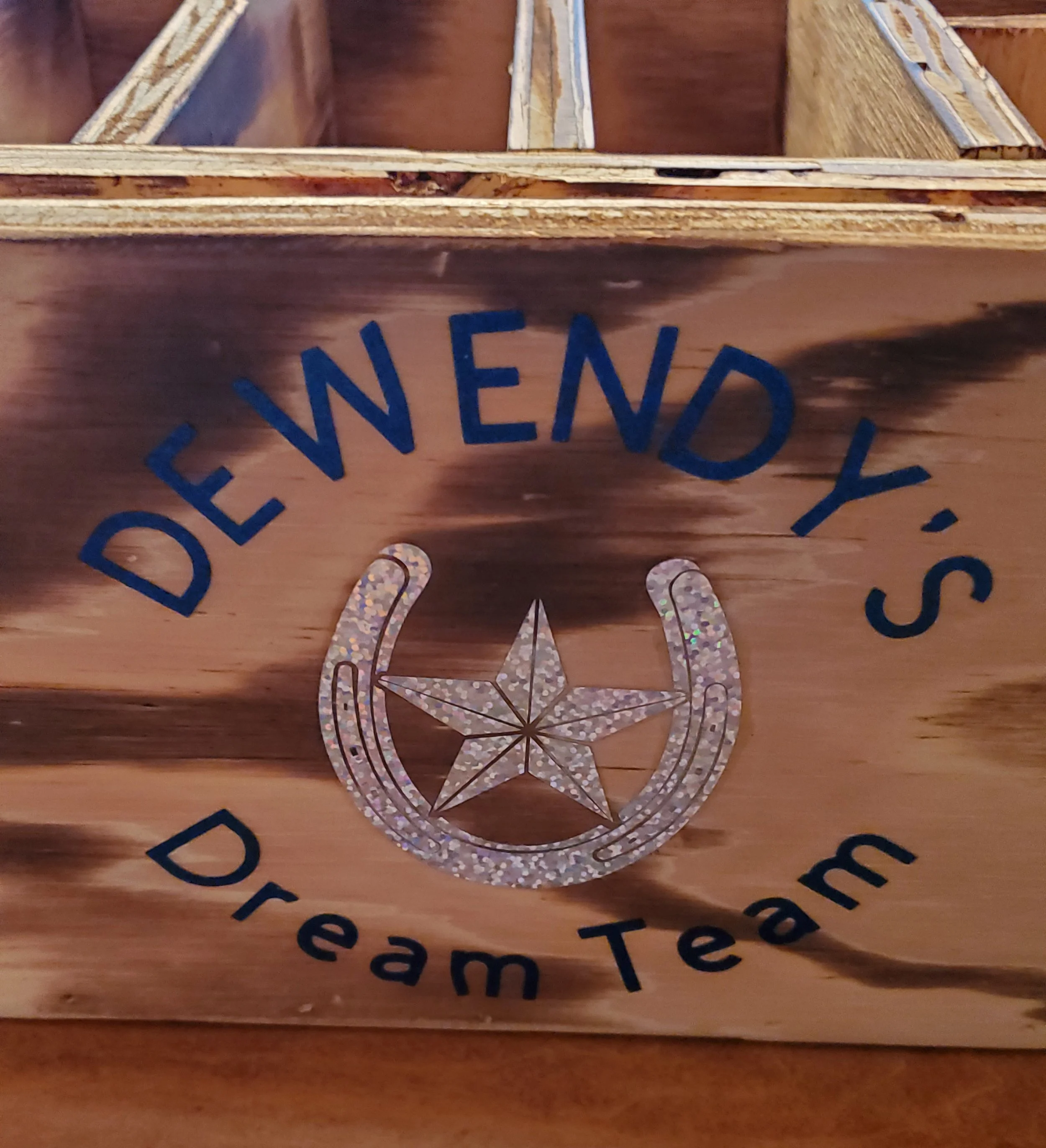 Wooden box with decal that says "Deliend Y's Dream Team" and features a horseshoe, star, and sparkles.