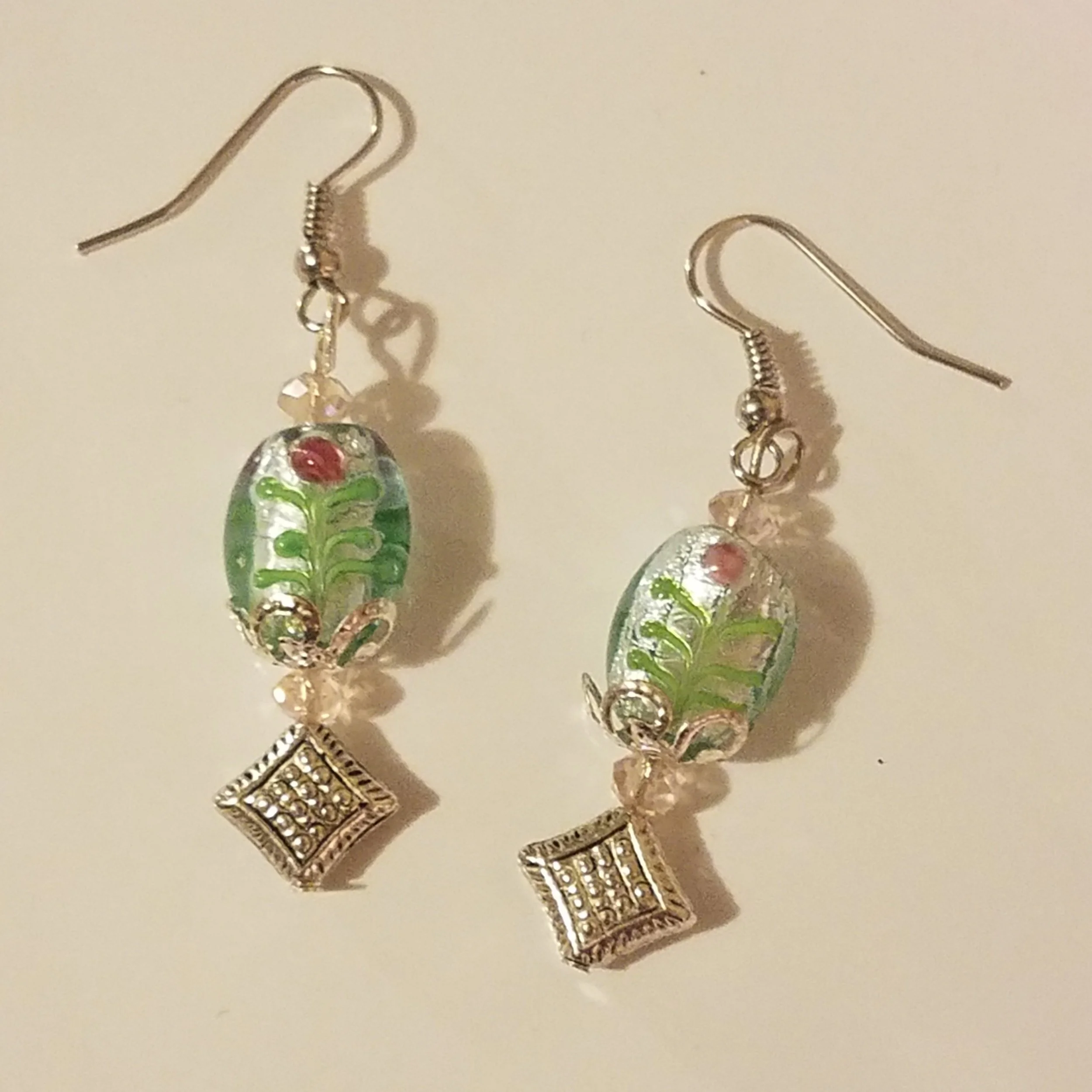 Silver earrings with multicolored beads and diamond-shaped pendants.