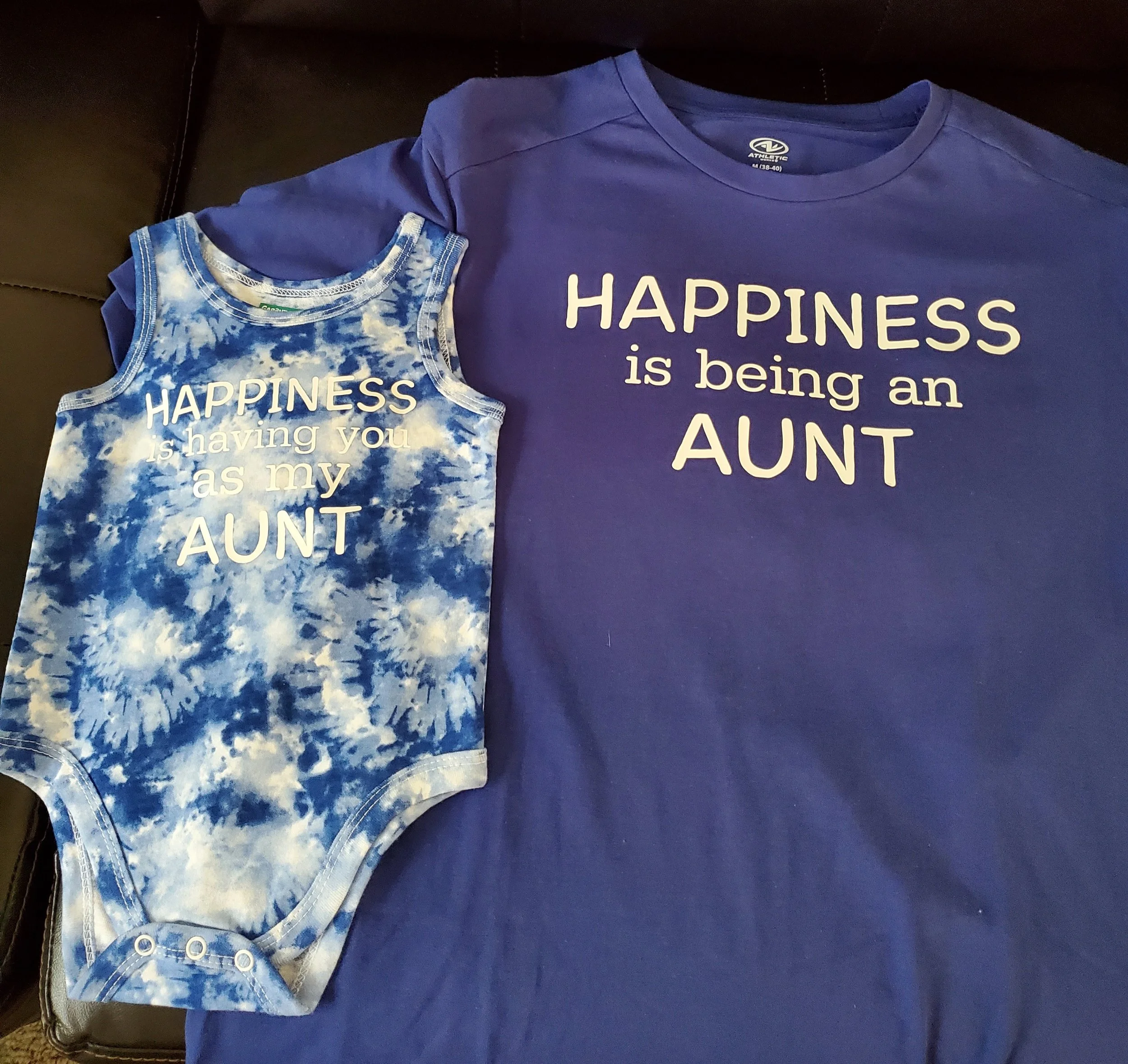 Matching blue shirts, one for an adult and one for a child, both with the quote 'HAPPINESS is being an AUNT' printed on them.