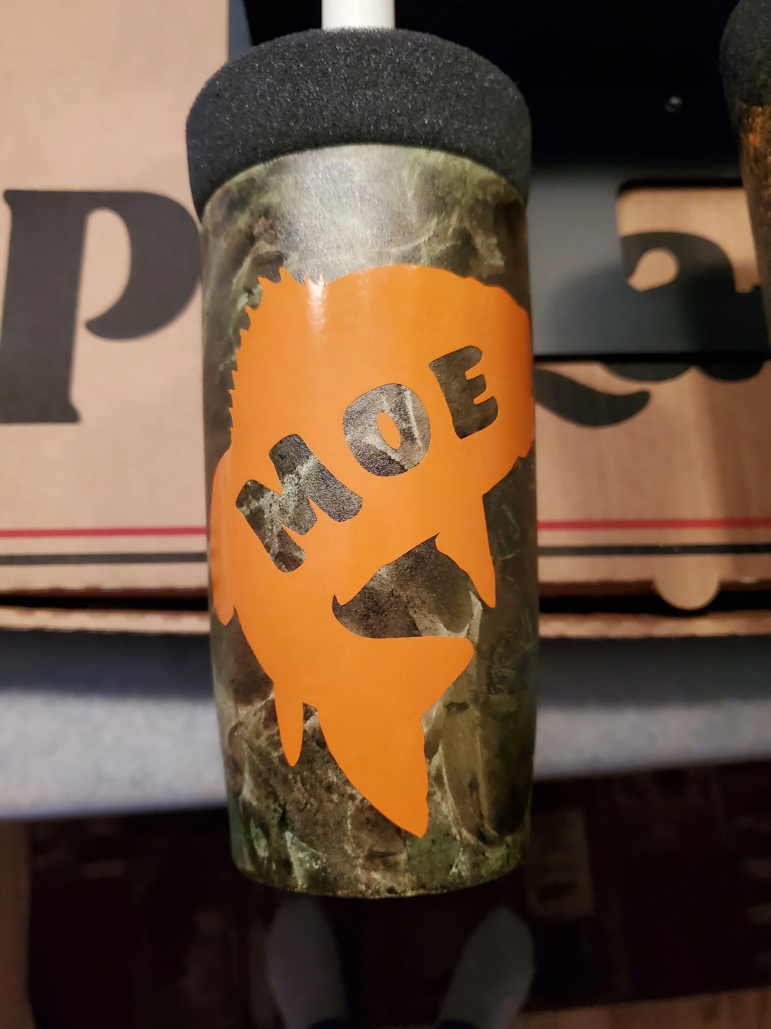 A matchbox with the word 'HOE' on a graffiti-style orange flame design.