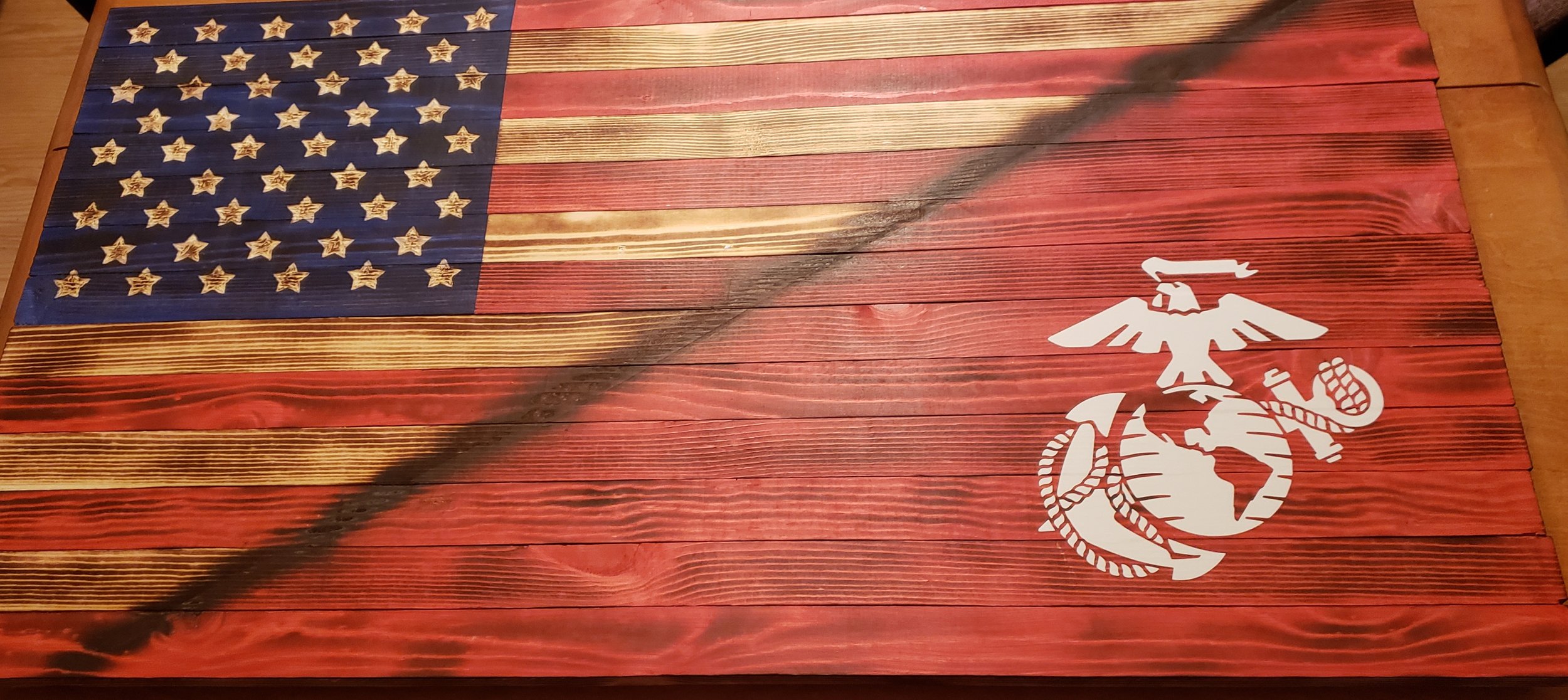 Wooden American flag with distressed stars and stripes, featuring the Marine Corps emblem in white on the lower right.