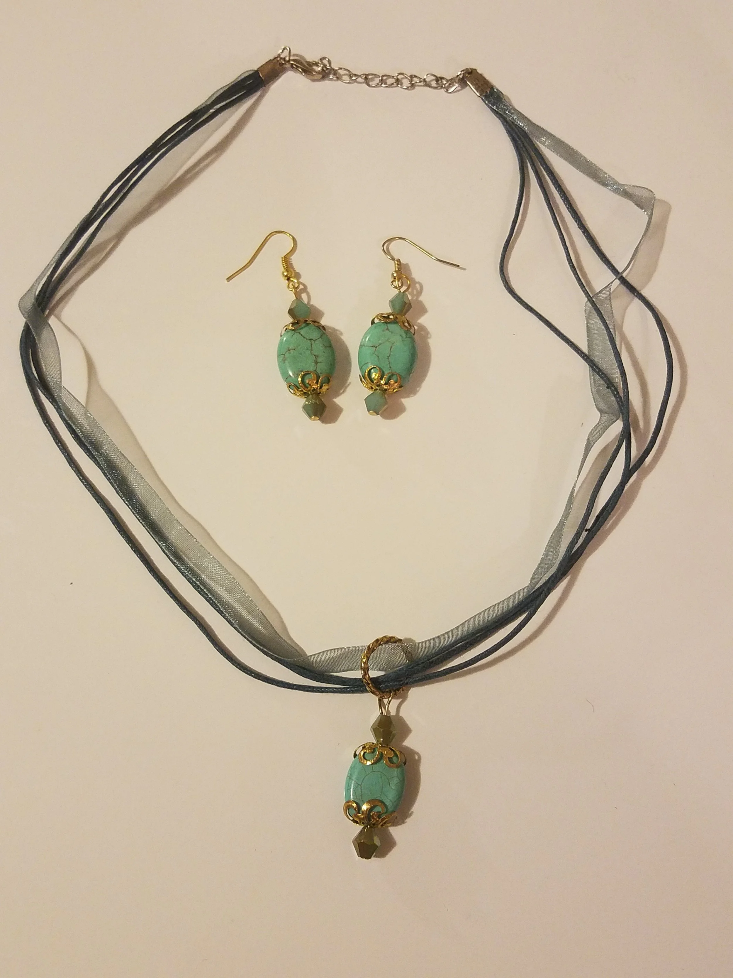 Turquoise beaded jewelry set with a necklace and matching earrings, displayed on a white background.
