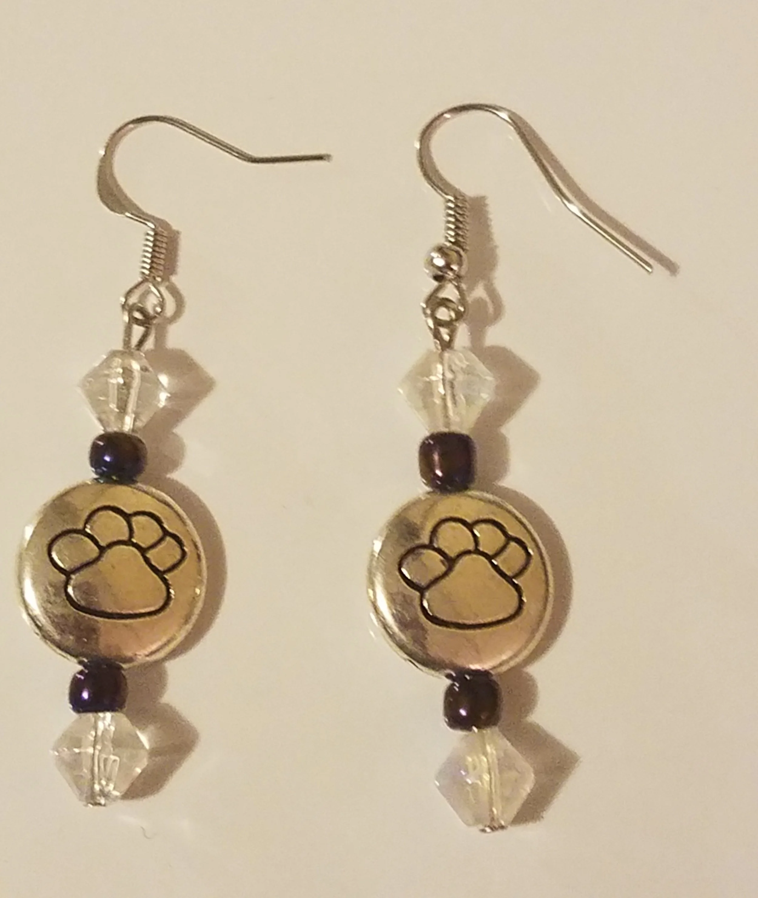 Pair of earrings with paw print charm, clear and dark beads, and small crystals.
