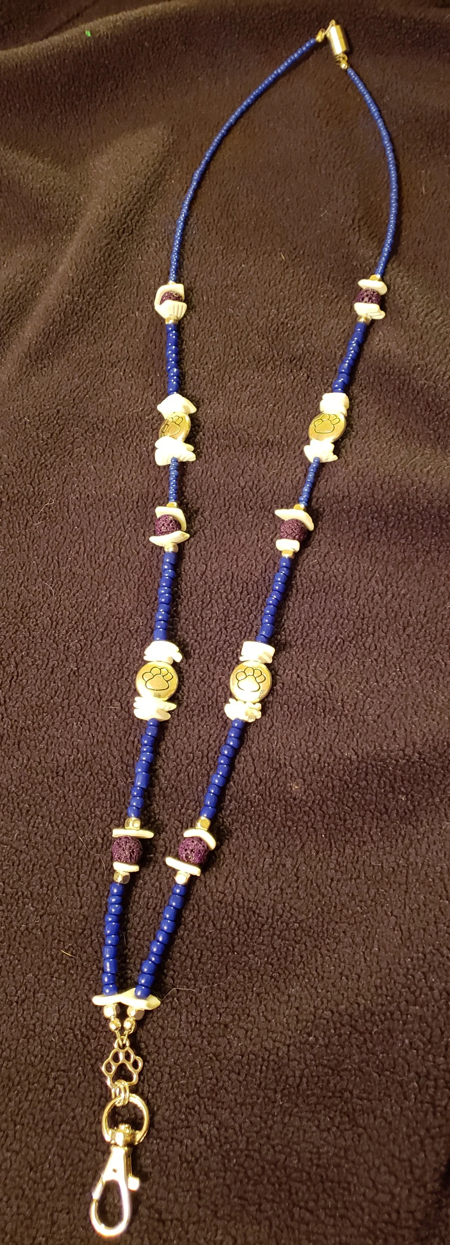 Blue beaded dog collar with white and purple accents and a metal clasp.