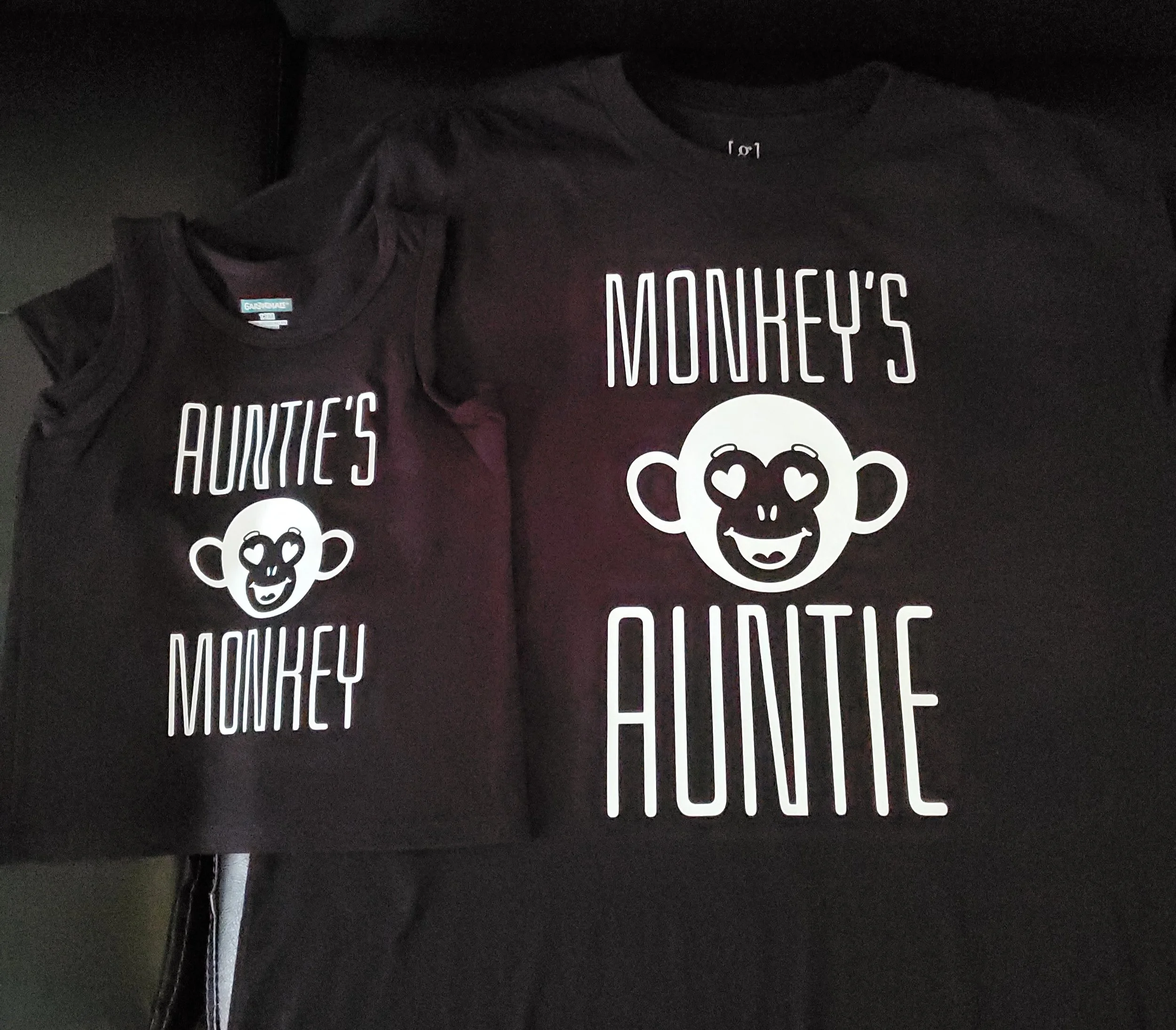 Matching black T-shirts with white text and a monkey face graphic that says 'Auntie's Monkey'.
