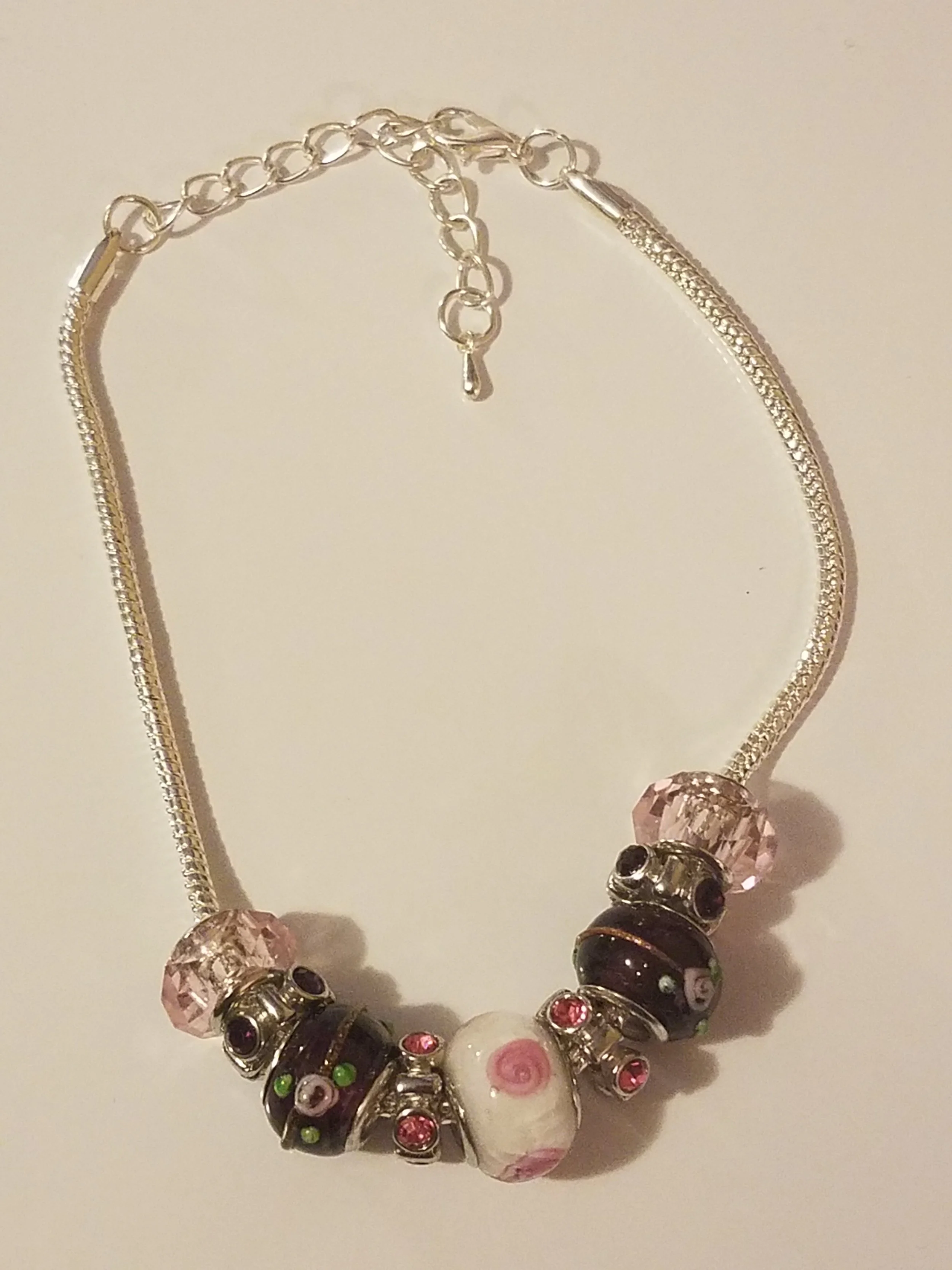 Silver necklace with pink, black, white, and rhinestone beads.