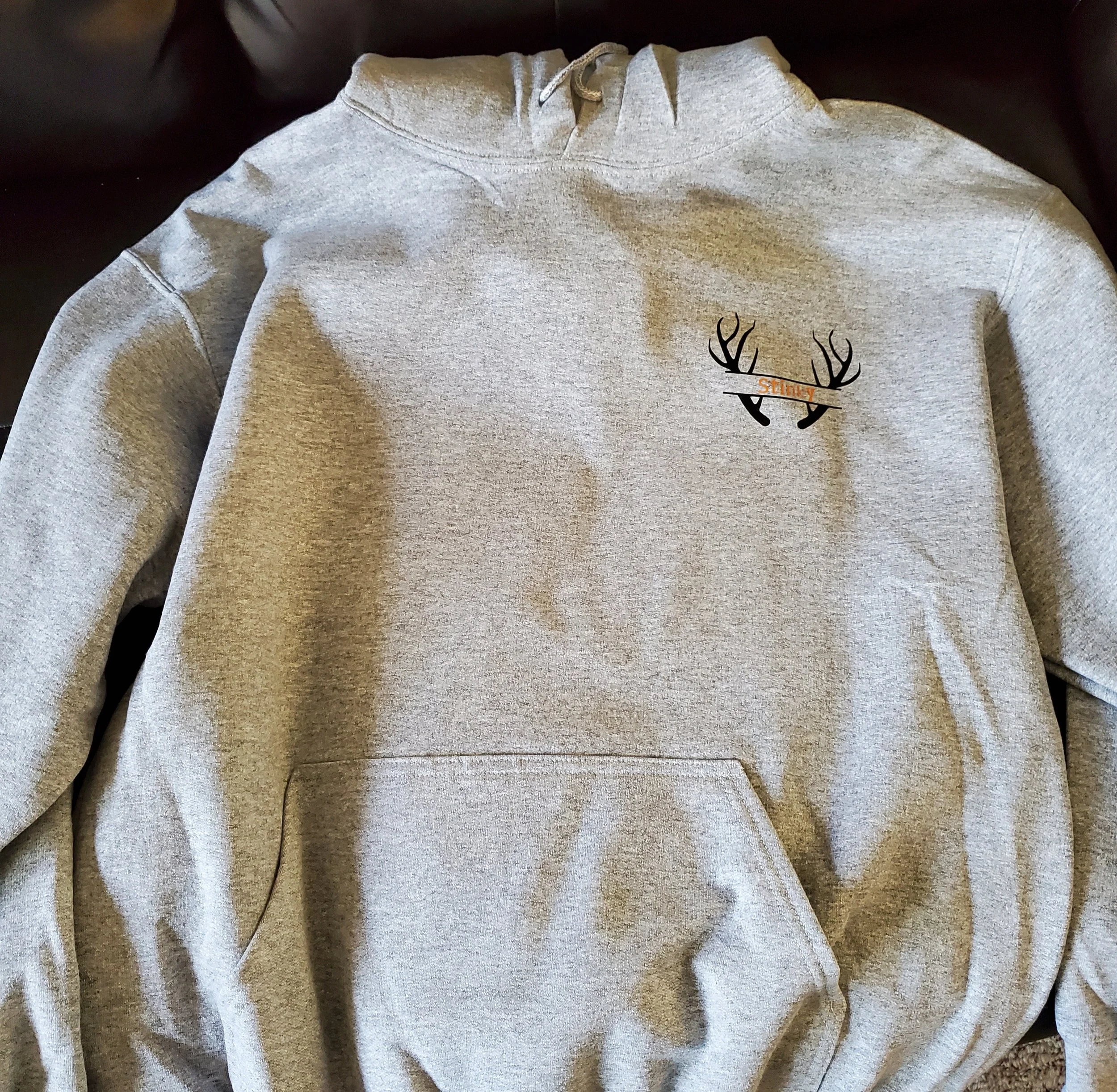 Gray hooded sweatshirt with a small graphic of a deer head with antlers on the chest.