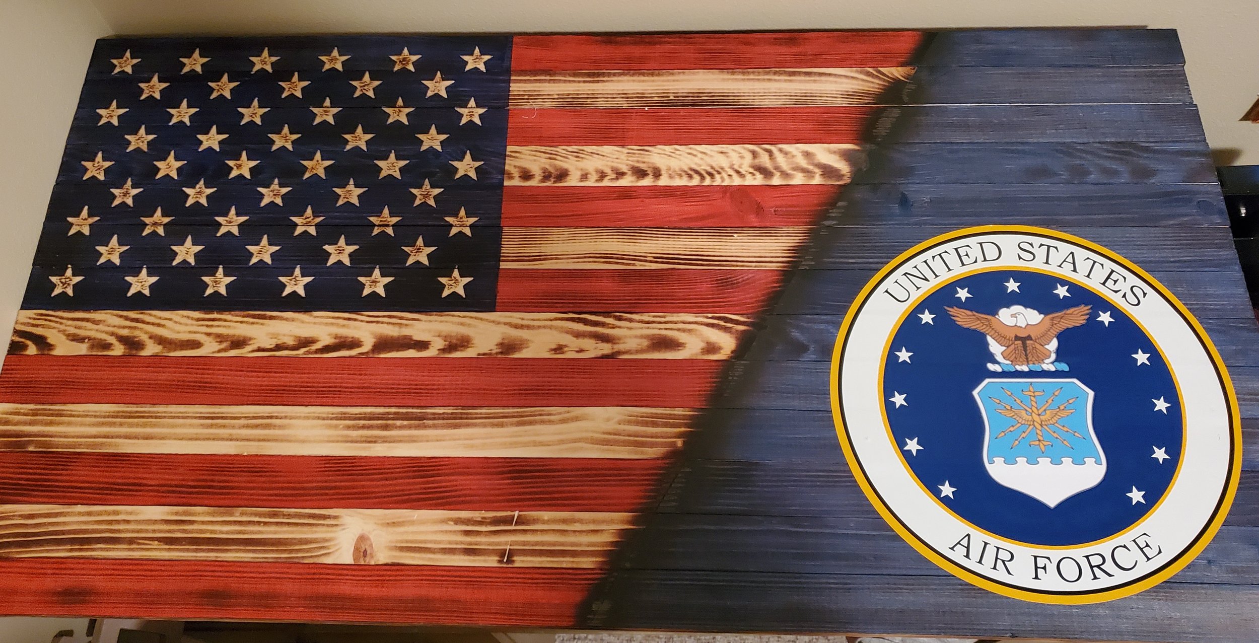 A wooden plaque featuring the American flag on the left side and the United States Air Force emblem on the right side.