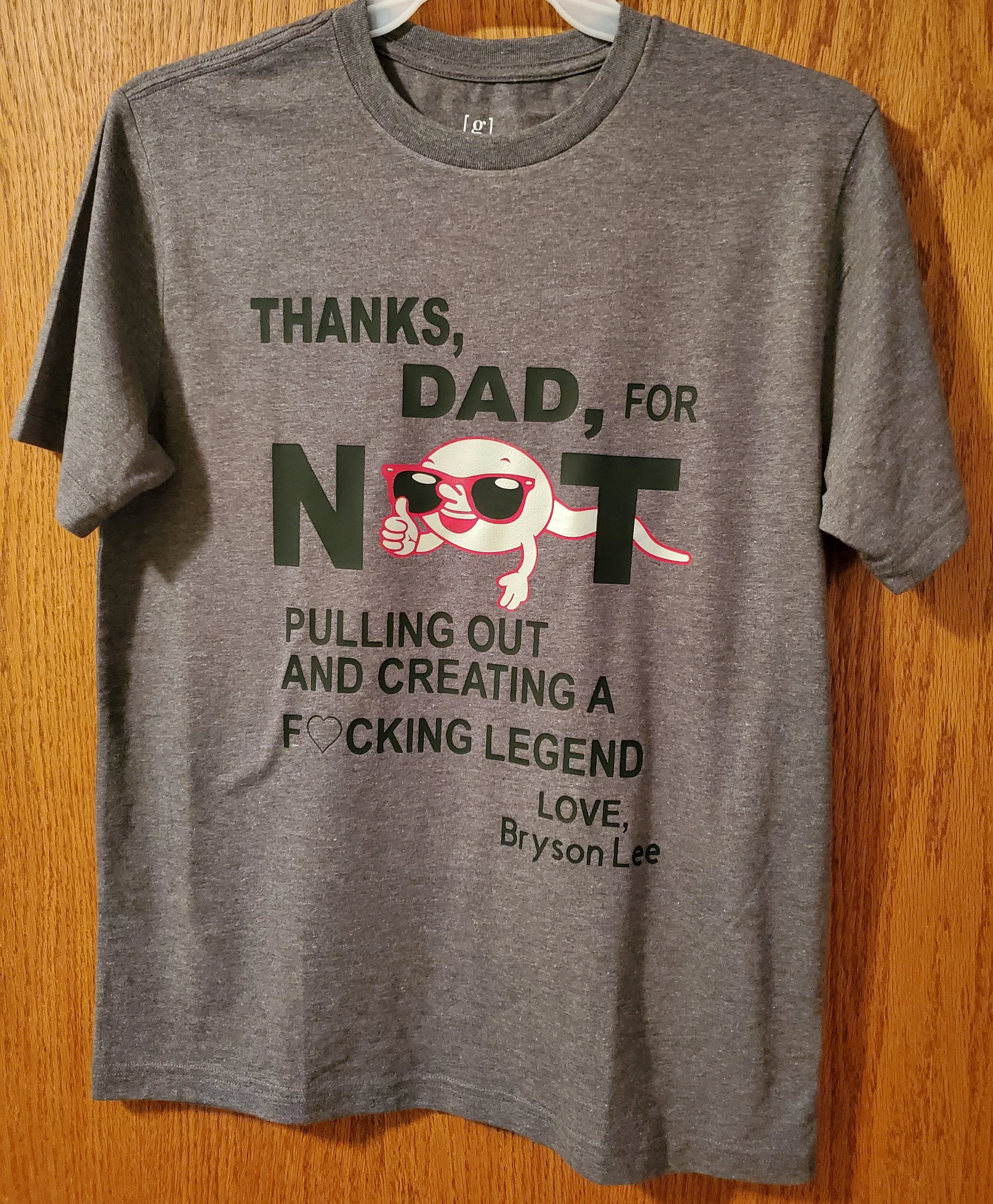 Gray T-shirt with a graphic of a cartoon snake wearing sunglasses, along with the text: 'Thanks, Dad, for not pulling out and creating a F***ing legend. Love, Bryson Lee.'