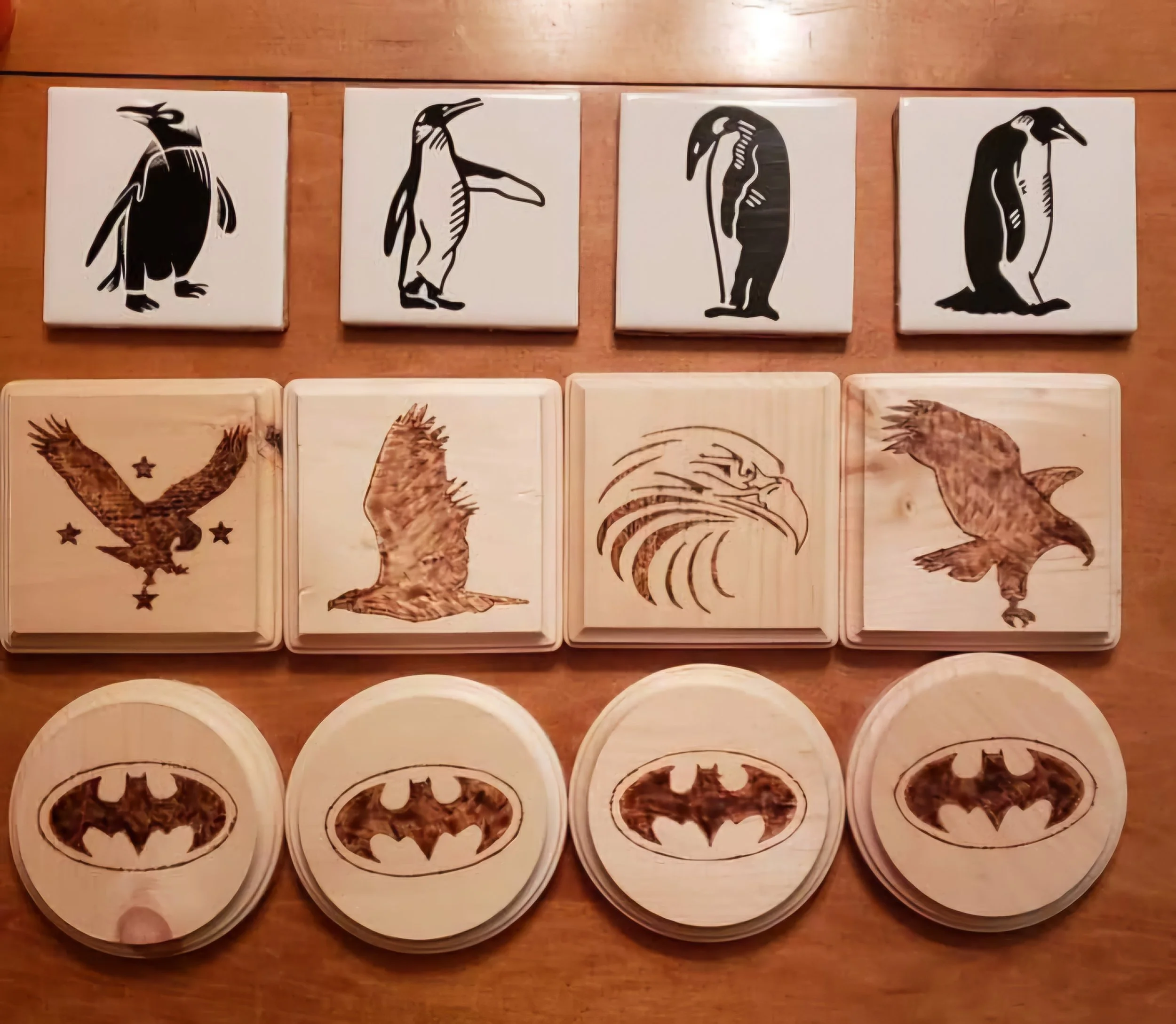 A collection of Batman-themed puzzle pieces, featuring bird and eagle images, arranged on a wooden surface.
