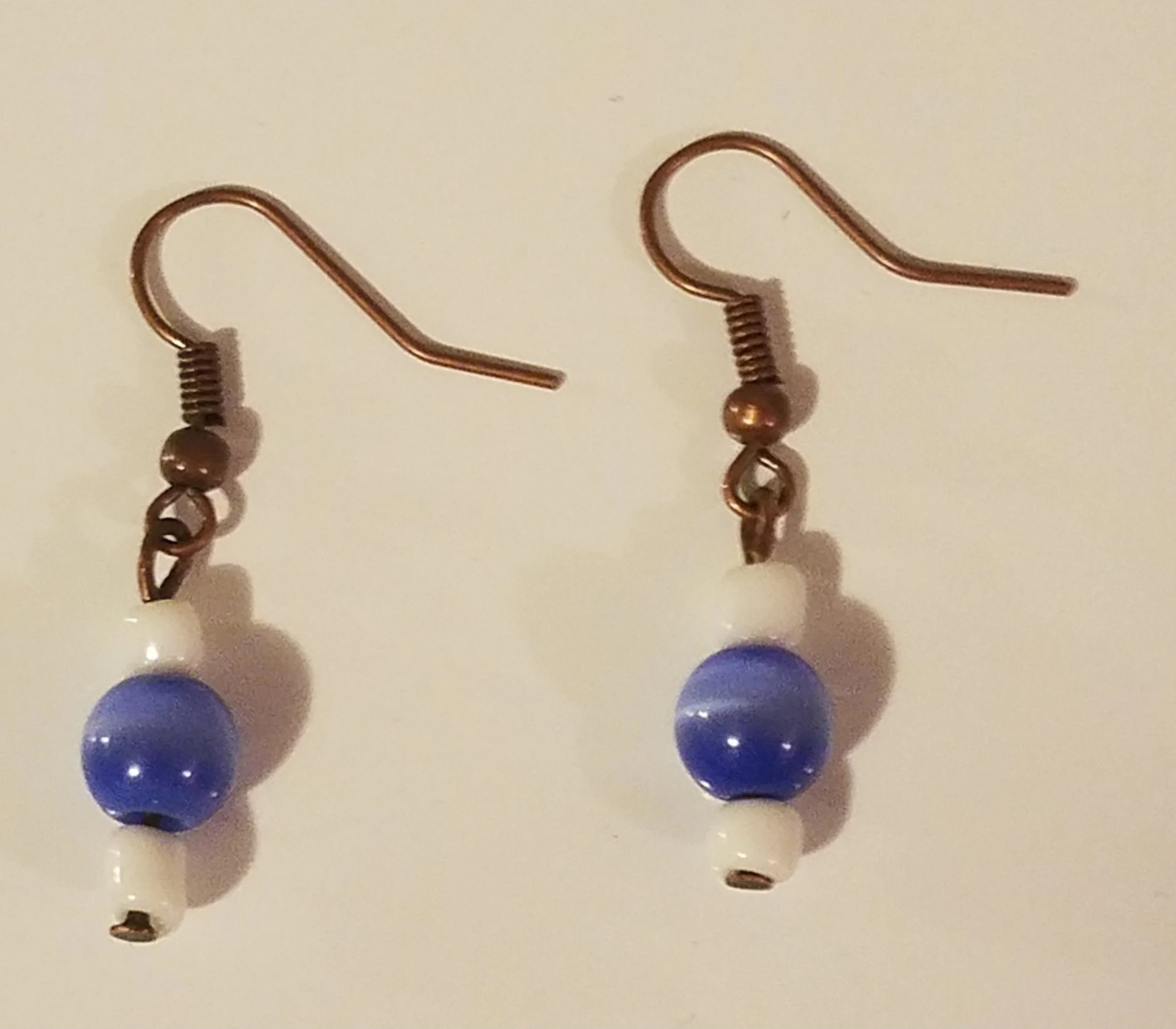 Pair of dangle earrings with blue, white, and copper beads.