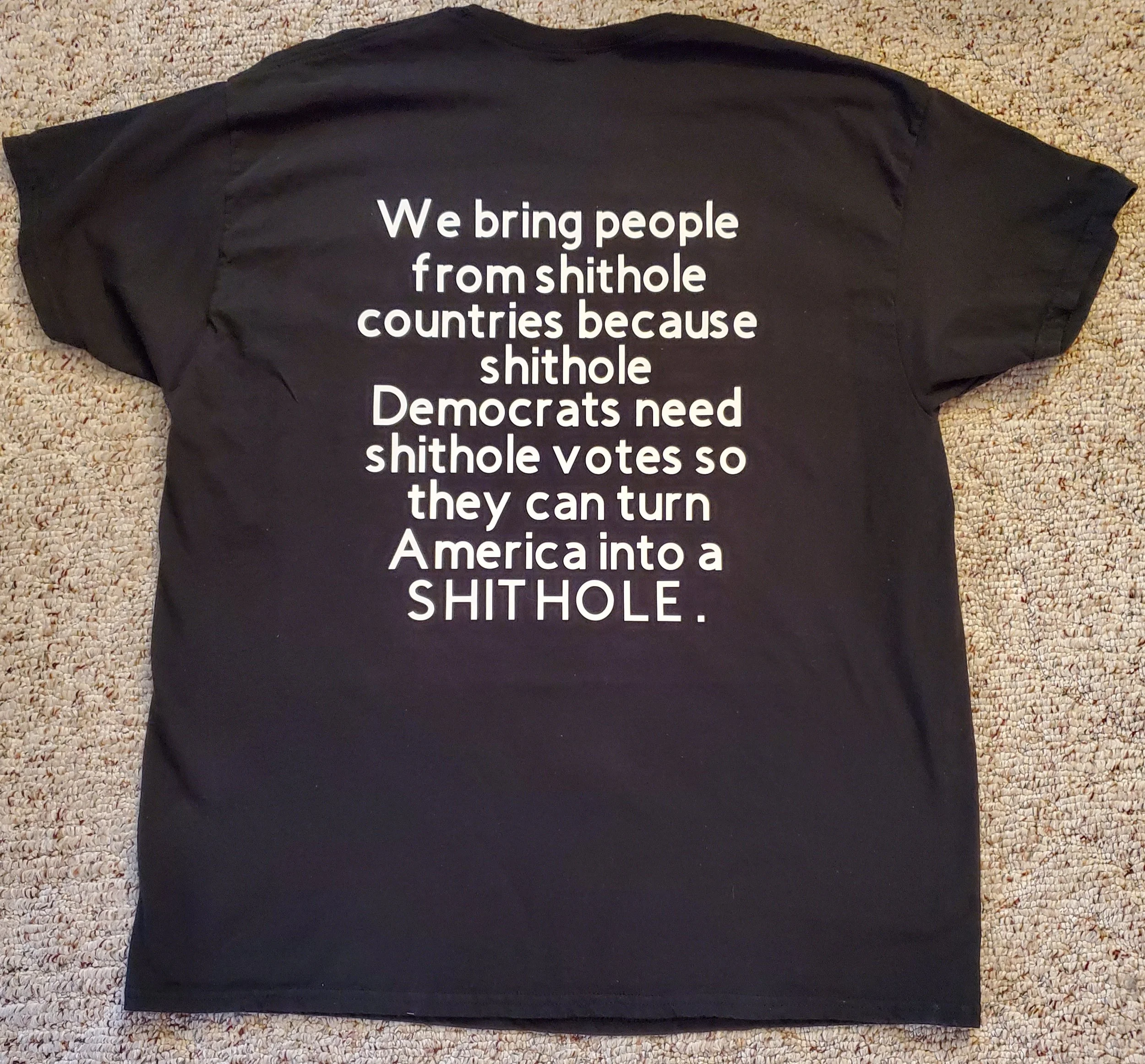 Black T-shirt with white text that reads: 'We bring people from shithole countries because shithole Democrats need shithole votes so they can turn America into a SHITHOLE.'
