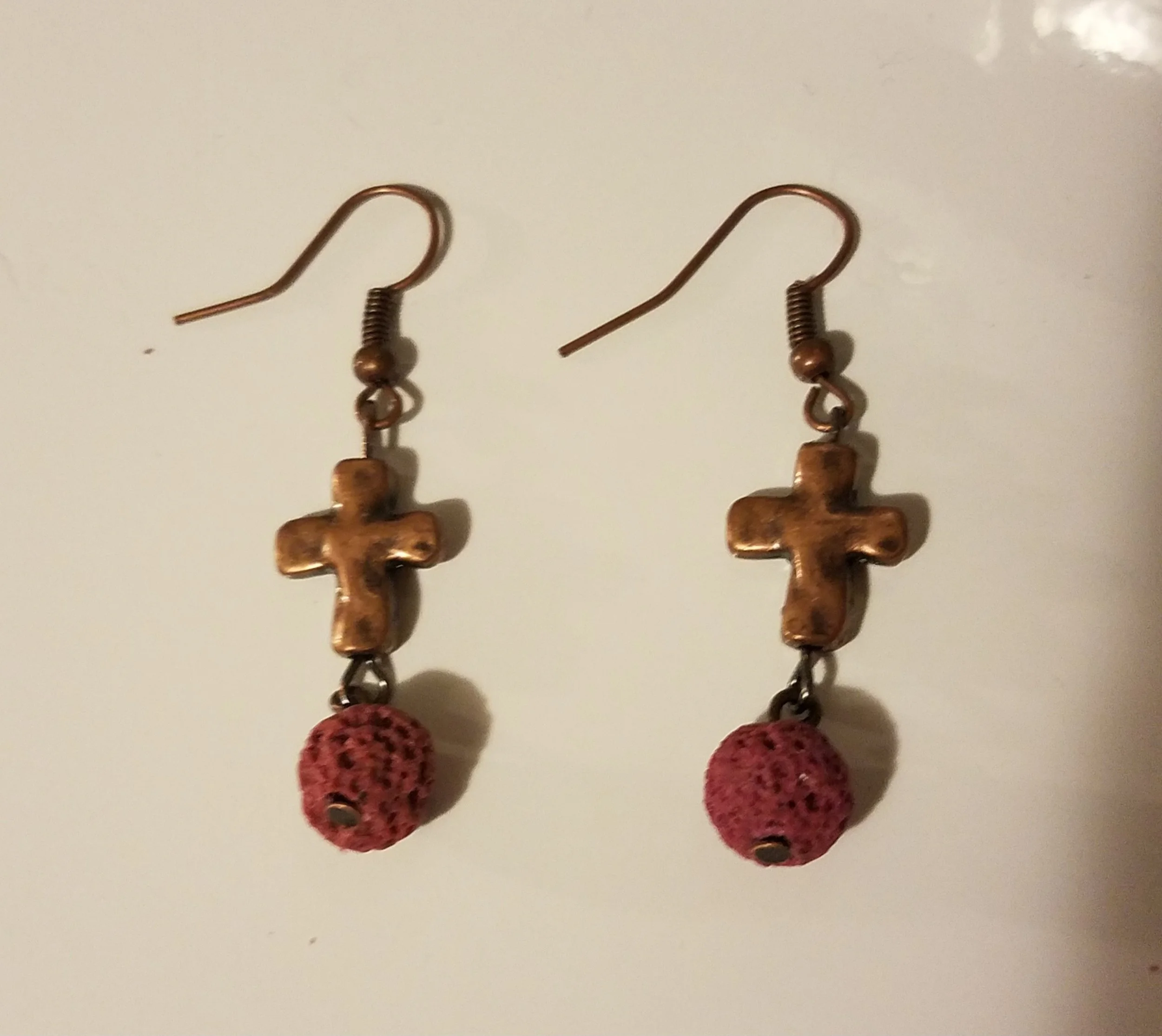Earrings with brass cross charms and pink crocheted beads.