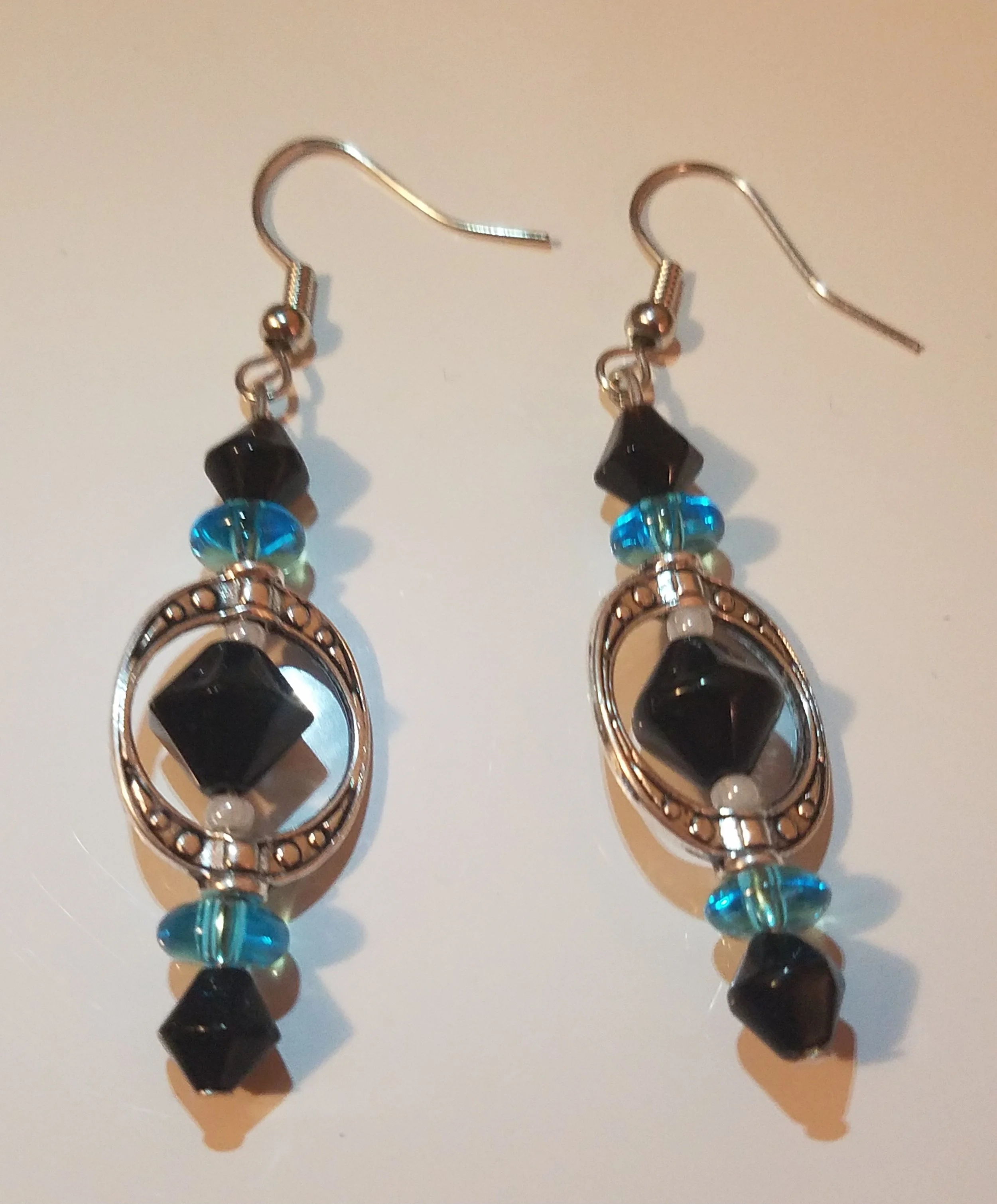 Pair of drop earrings with black, blue, and clear beads and silver-tone metal accents.