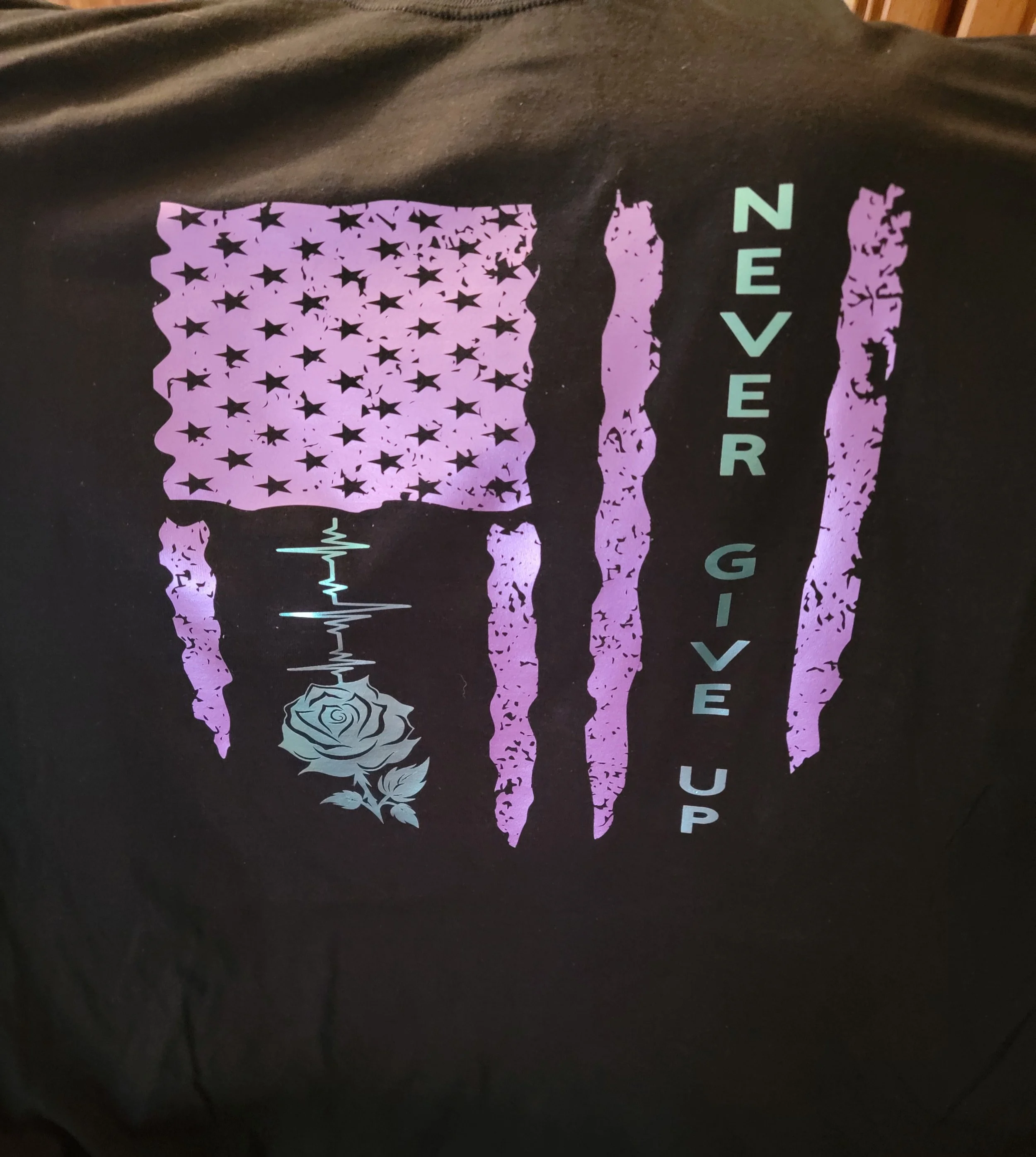 Design featuring American flag with purple stars, three claw marks, a rose, and the phrase 'Never Give Up'.