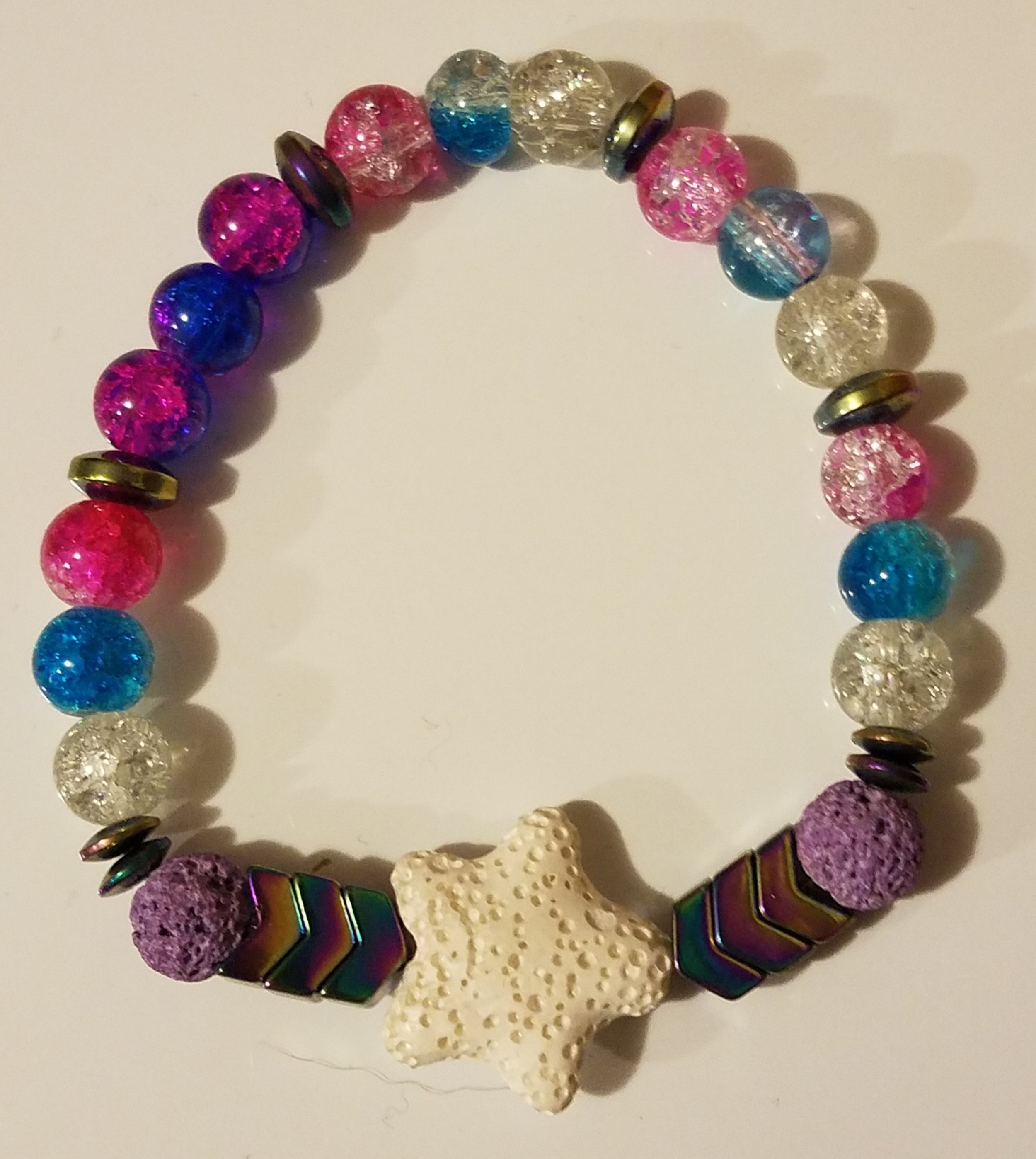 Colorful beaded bracelet with a starfish charm and various round beads in pink, blue, purple, and clear colors.