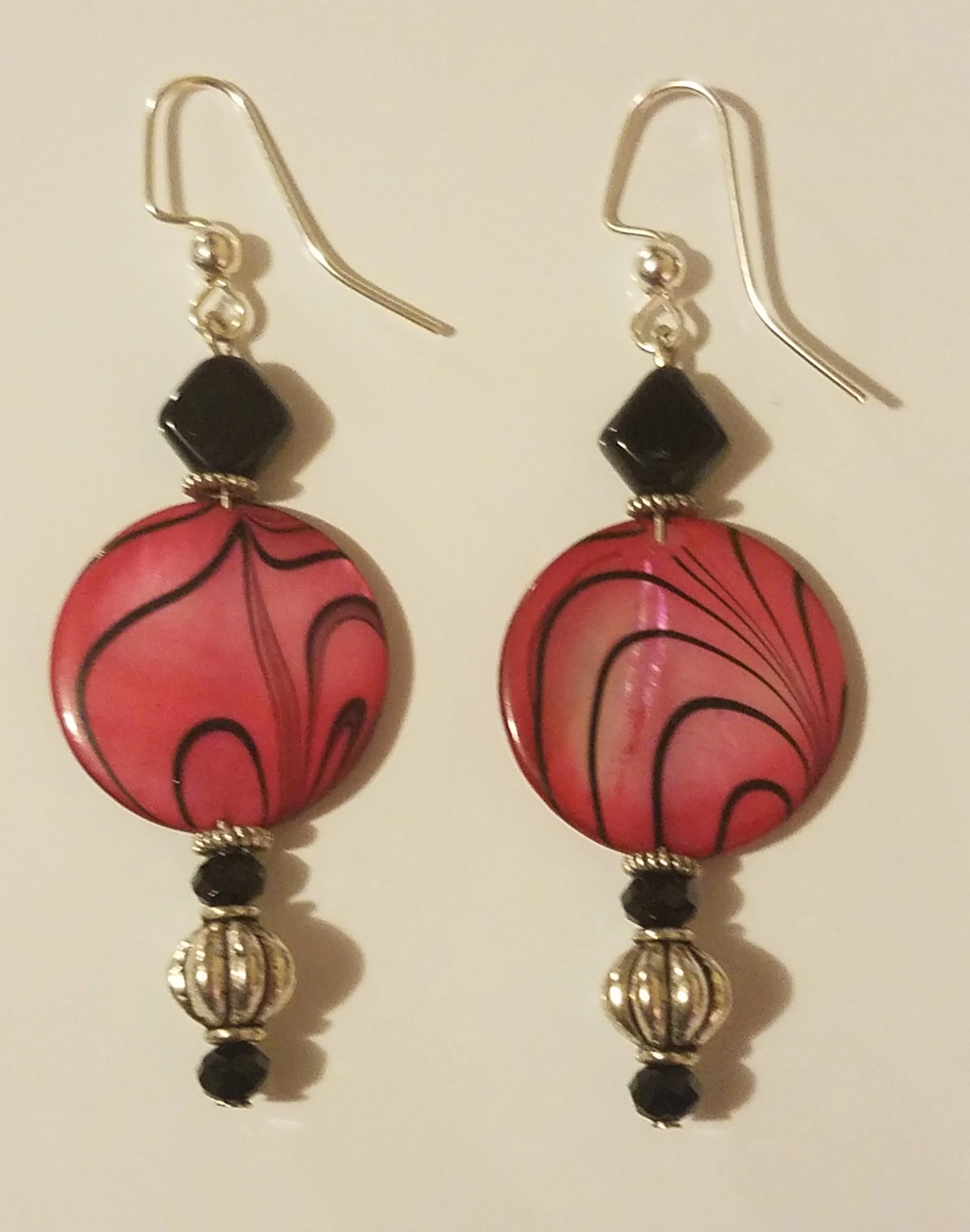 Pink and black marble-patterned dangle earrings with black beads and silver accents.