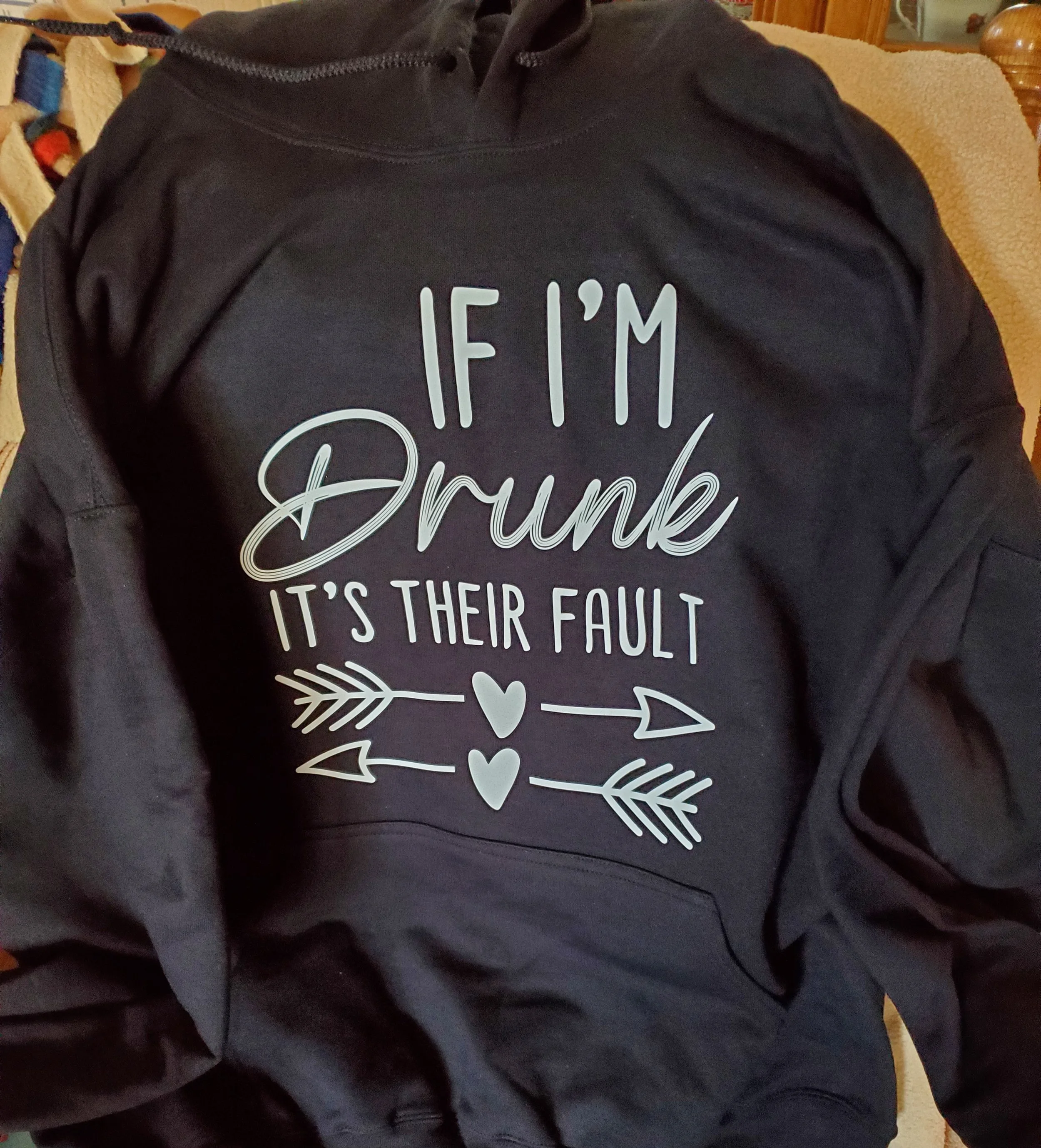Black hoodie with the humorous quote: "If I'm Drunk It's Their Fault" along with decorative arrows and hearts.
