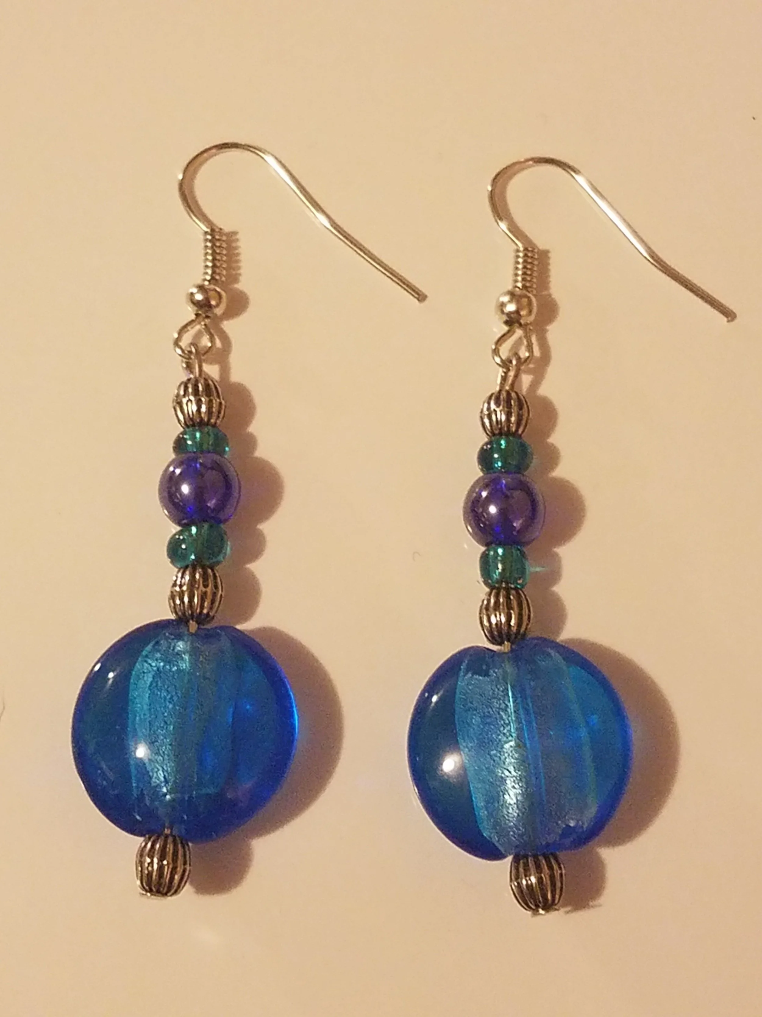 Blue and purple beaded dangle earrings with silver hooks.