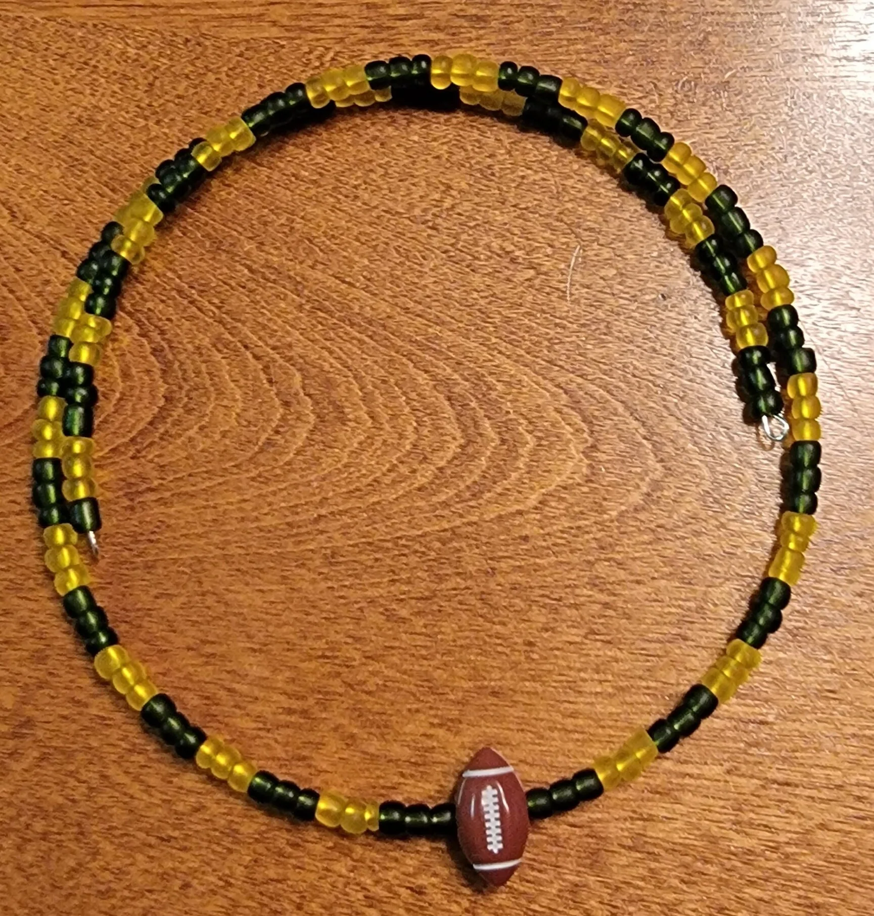 Beaded necklace with black and yellow beads and a small football-shaped charm.