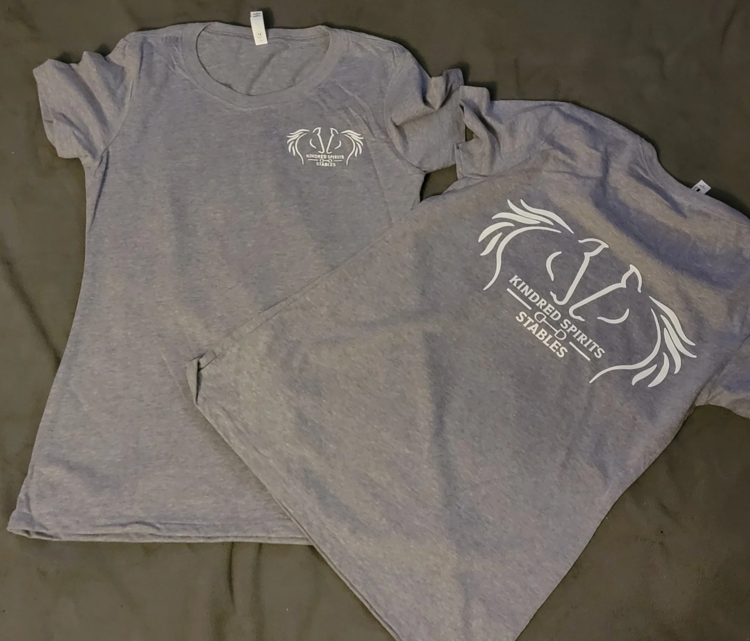 Gray T-shirt and sweatshirt with a logo and text: 'Kindred Spirits Stables'.