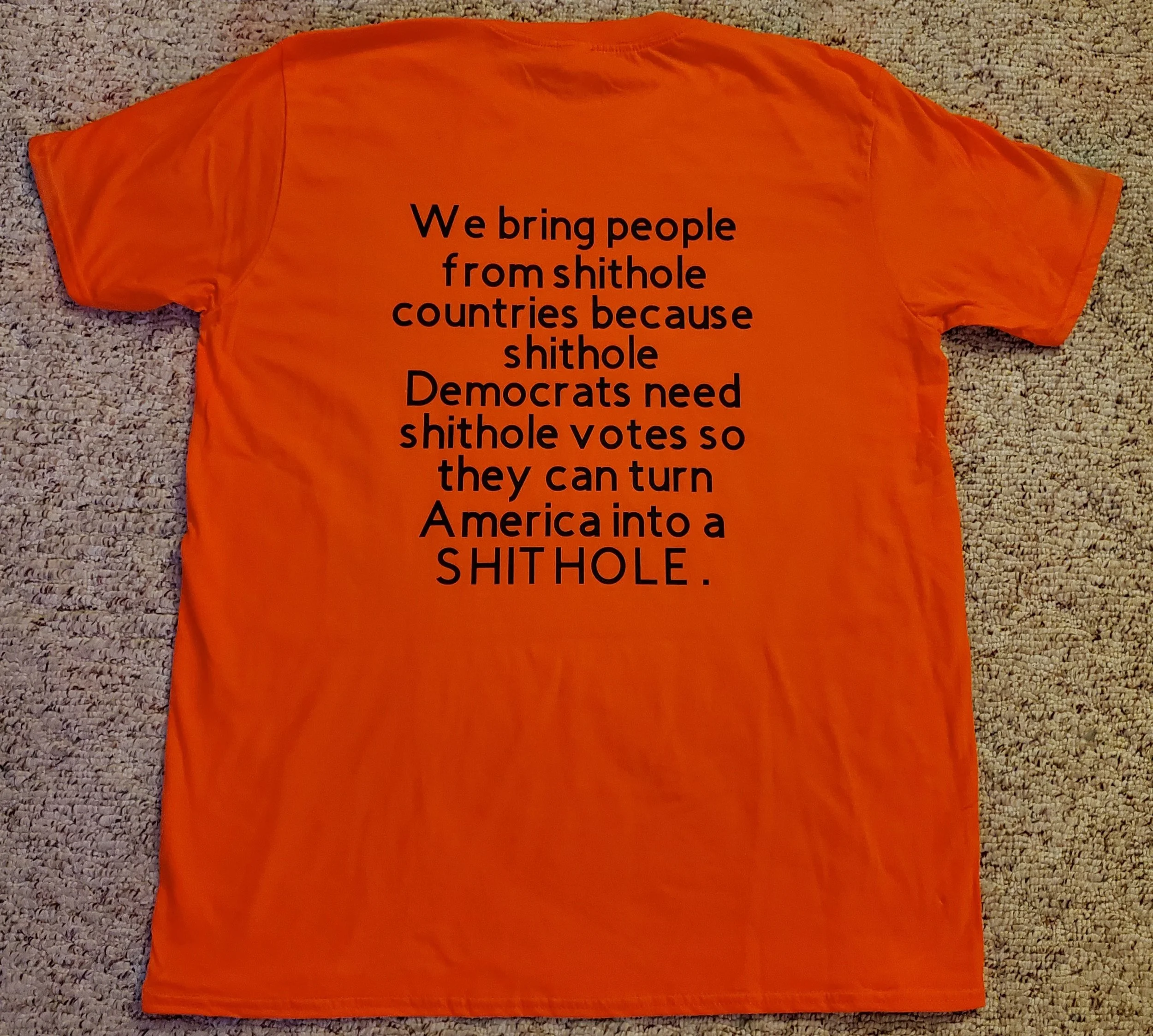 Orange T-shirt with black text that reads: "We bring people from shithole countries because shithole Democrats need shithole votes so they can turn America into a SHITHOLE."