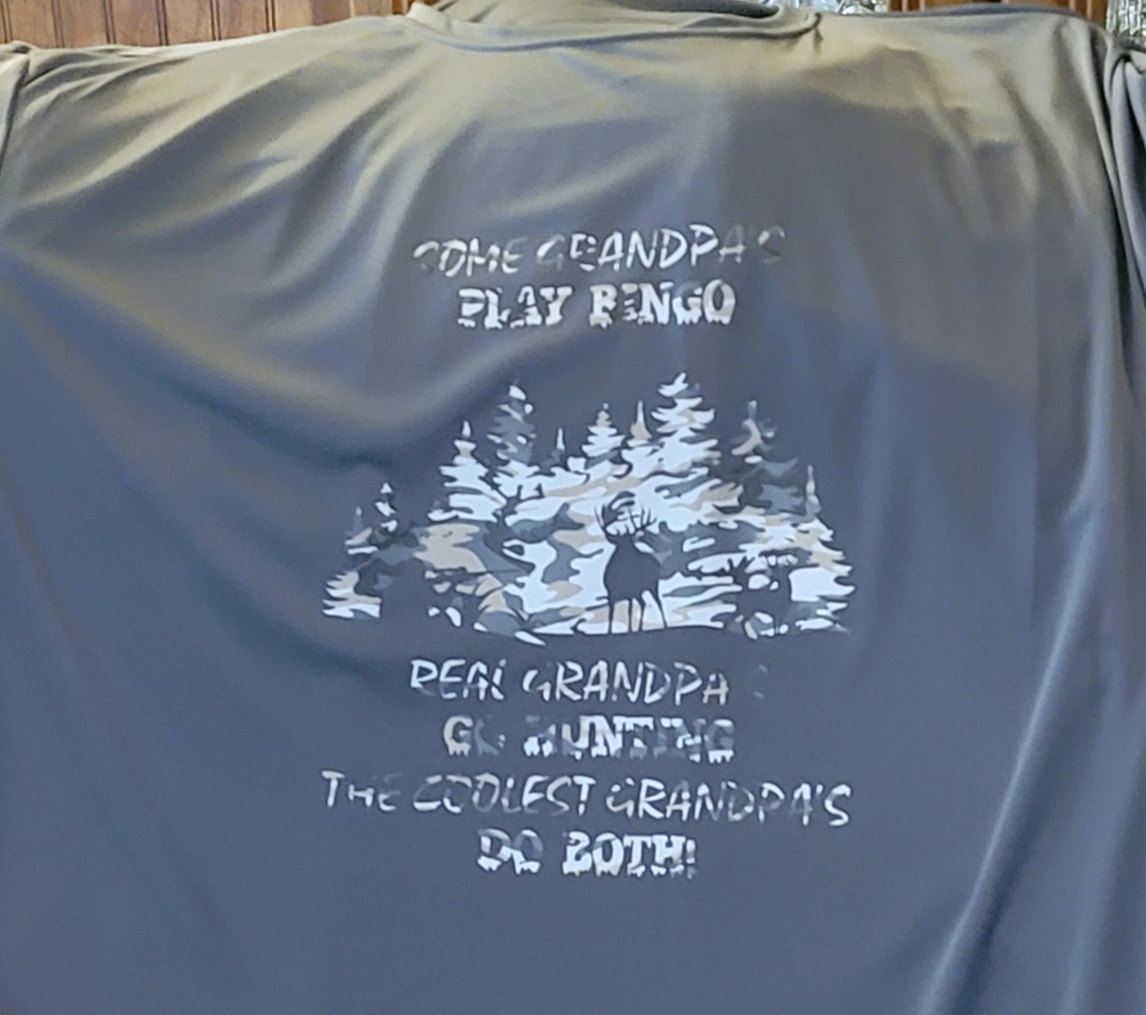 Grey sweatshirt with white graphic of trees and deer, and text reading "The Grandpa's Play Bingo. Dear Grandpa, Go Hunting. The Coolest Grandpa's Decoth."