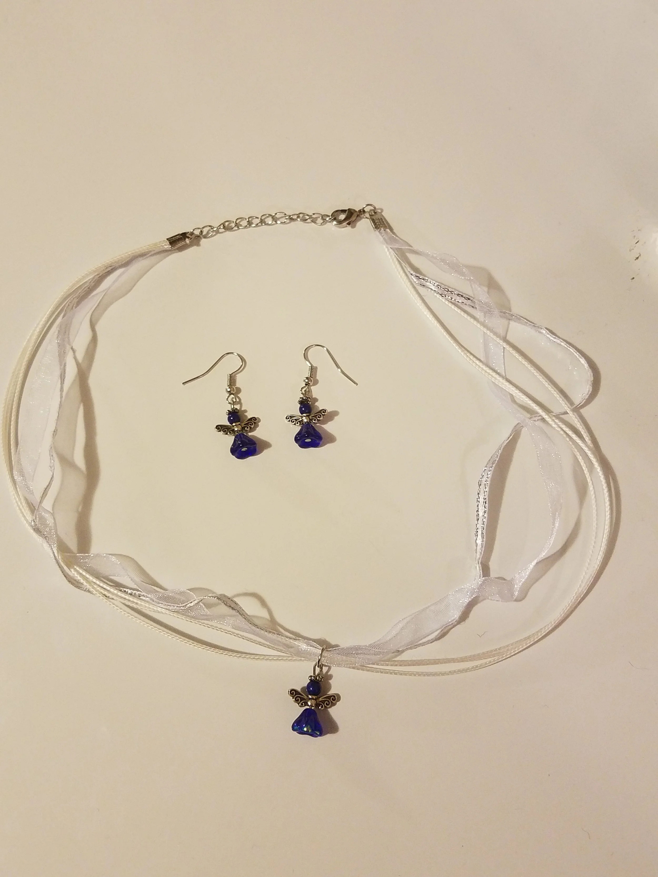 Blue and silver butterfly jewelry set including a necklace and earrings with ribbon details.