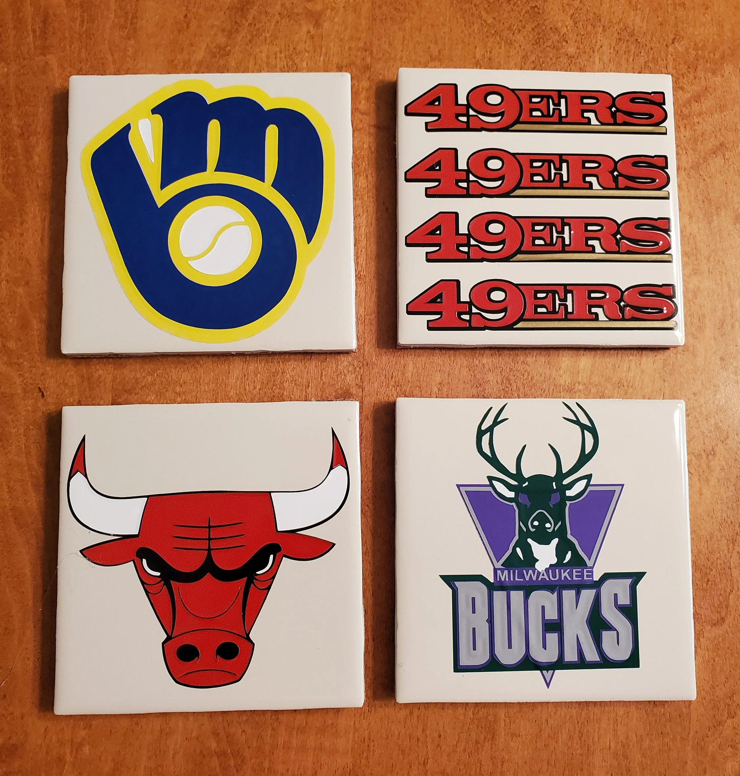 Four tiles with sports team logos: Milwaukee Brewers logo, multiple copies of San Francisco 49ers logo, Chicago Bulls logo, Milwaukee Bucks logo.