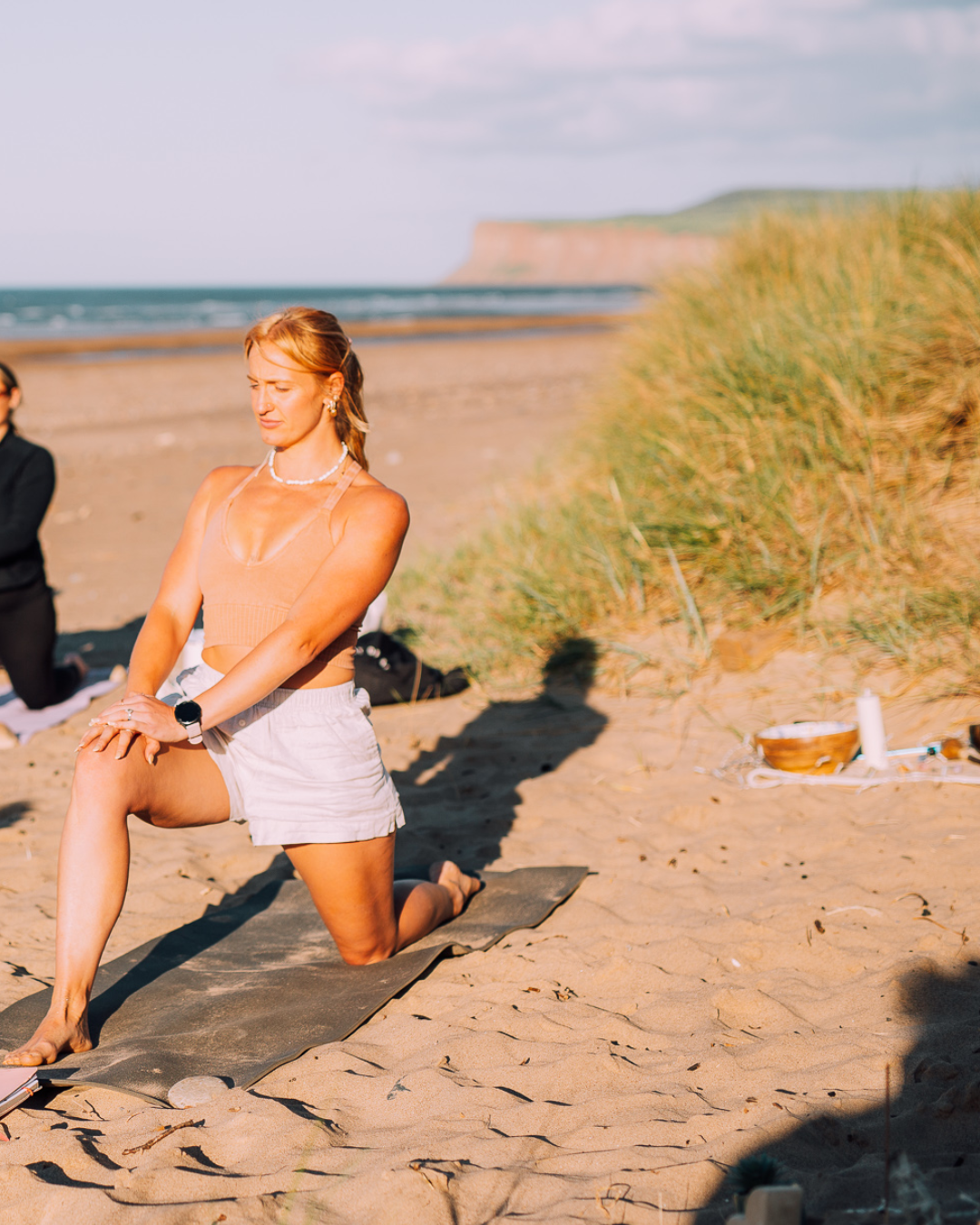 woman practicing yoga on the beach