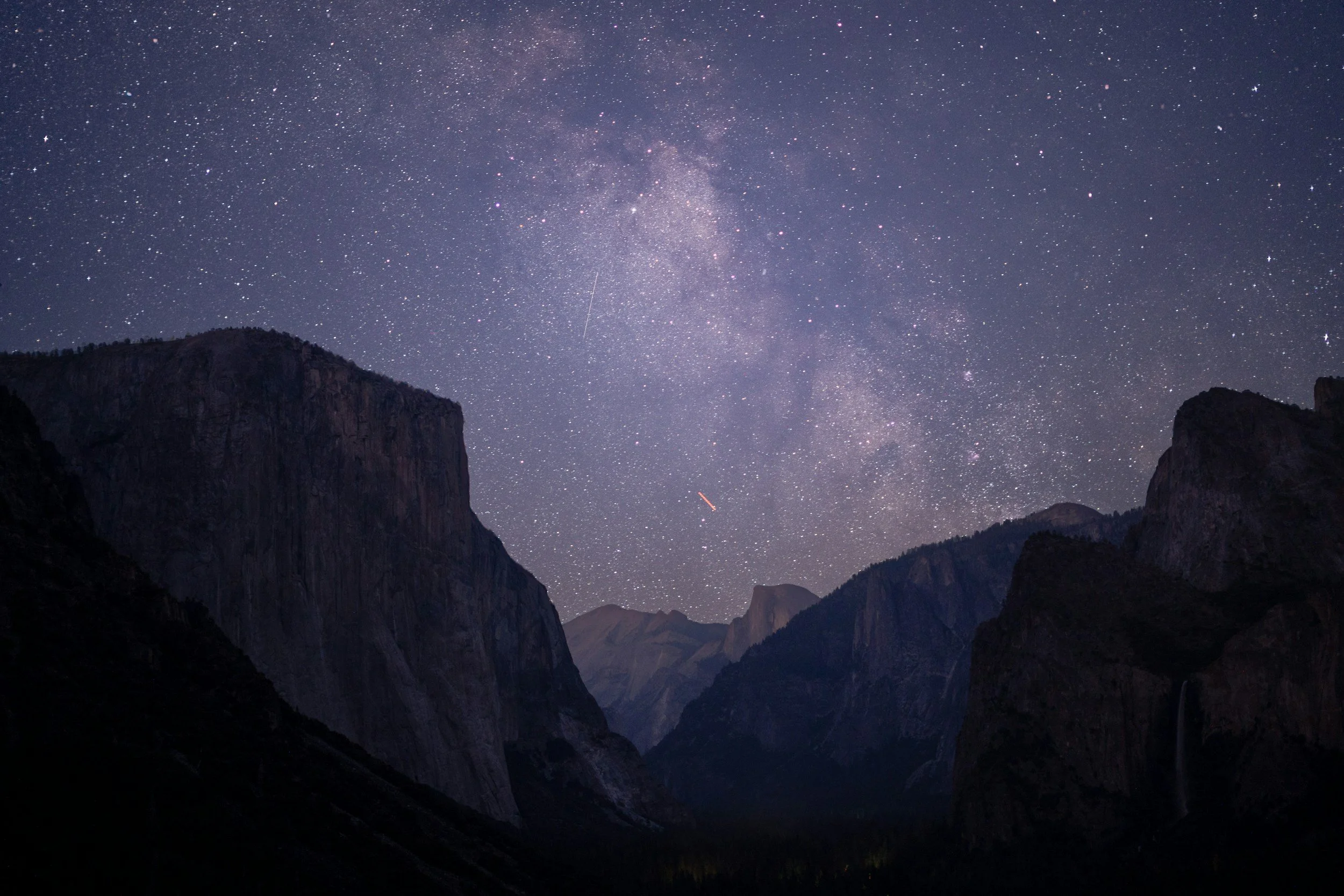 Starry night sky over a mountain landscape