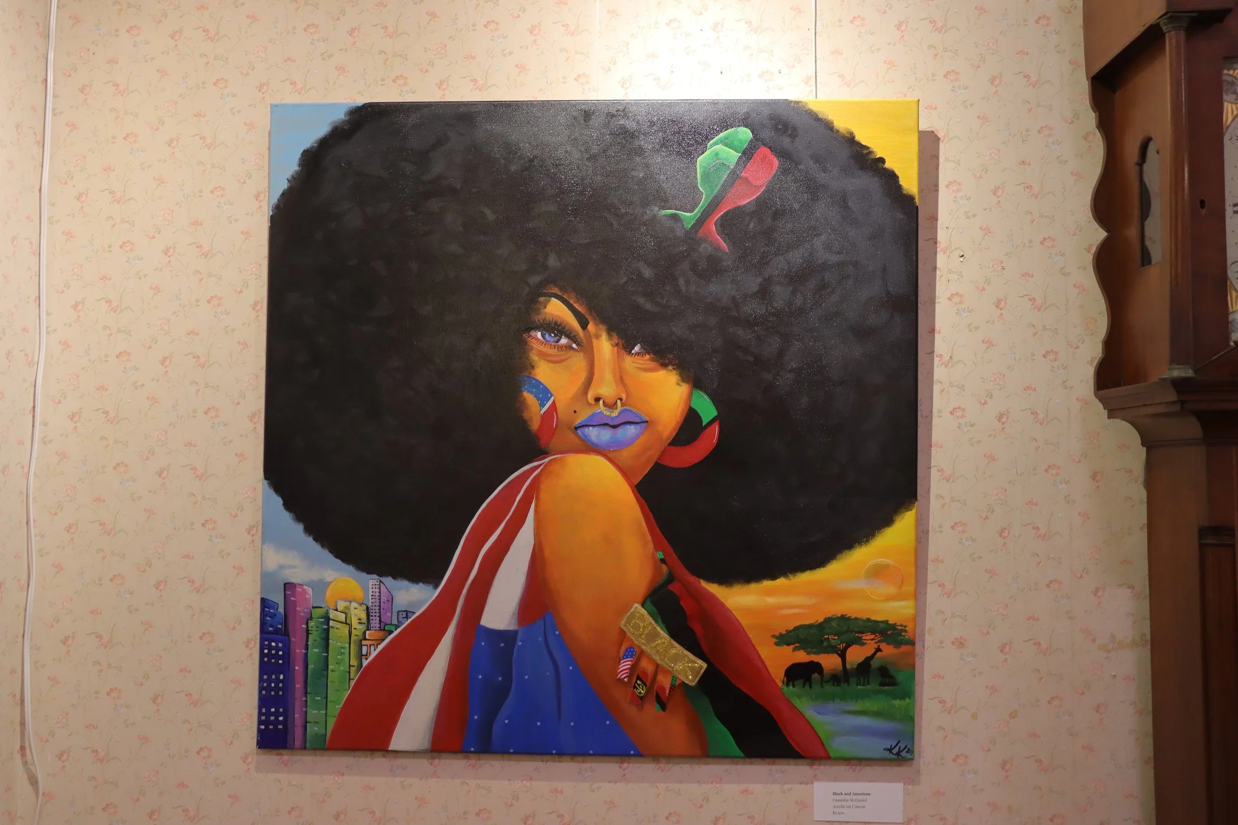 Colorful painting of a Black woman with large natural hair, bold makeup, and colorful earrings, set against a vibrant background with cityscape, landscape, and sunset elements.