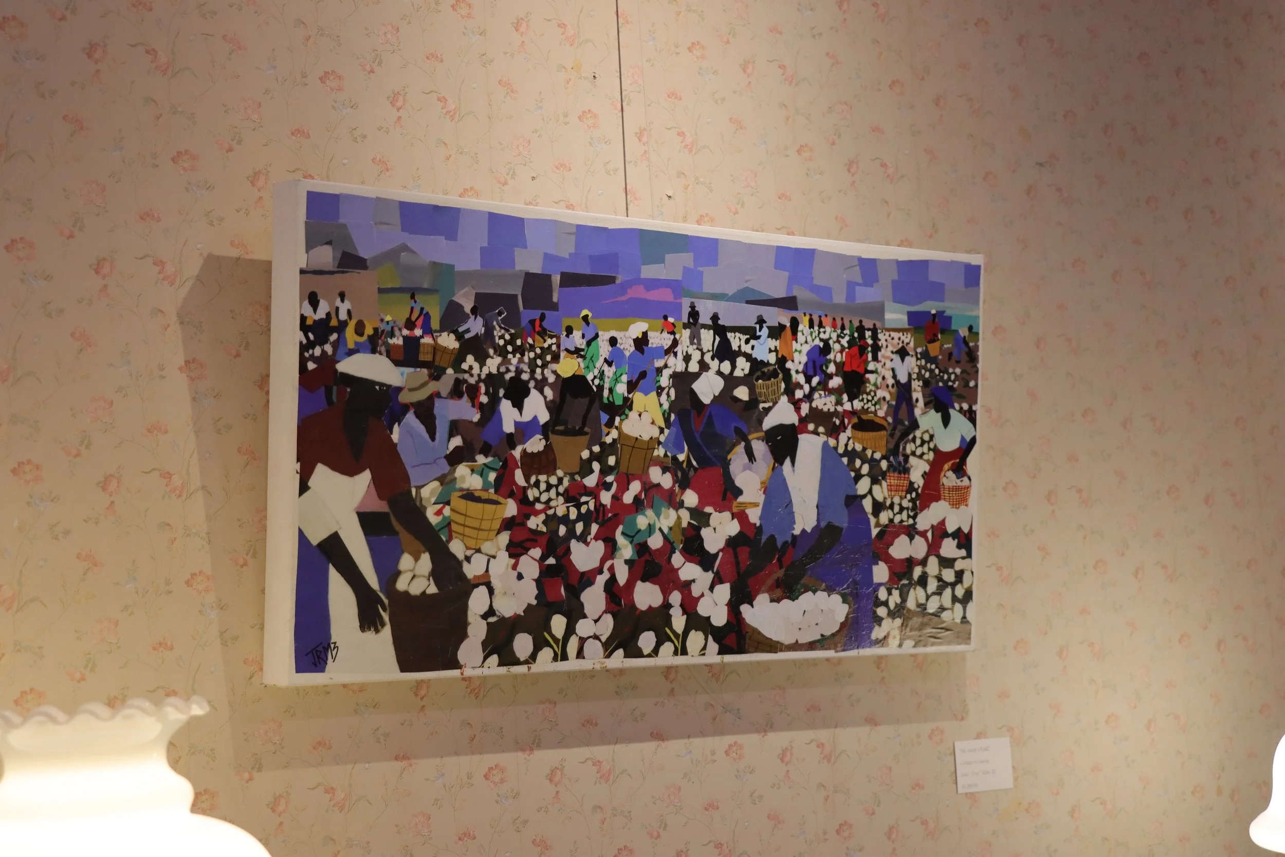 A colorful painting depicting a busy marketplace scene with many people, some carrying baskets or umbrellas, under a mostly cloudy sky.