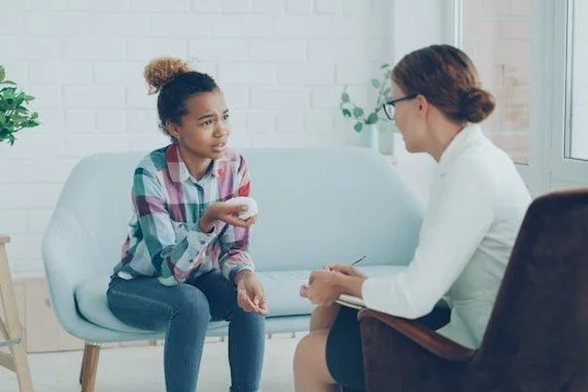 therapist-talking-to-a-young-girl-on-couch
