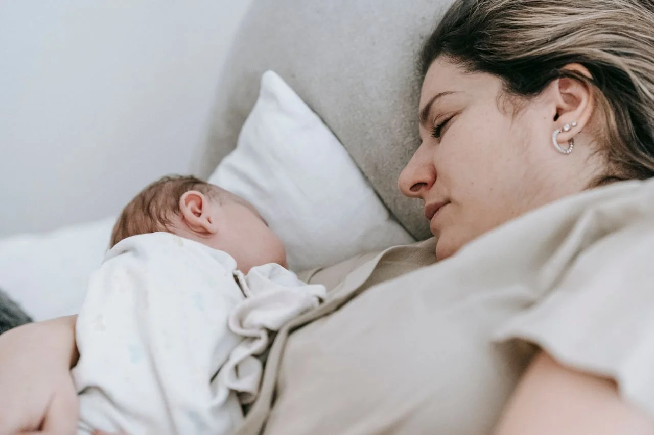 mother-with-baby-sleeping-on-bed