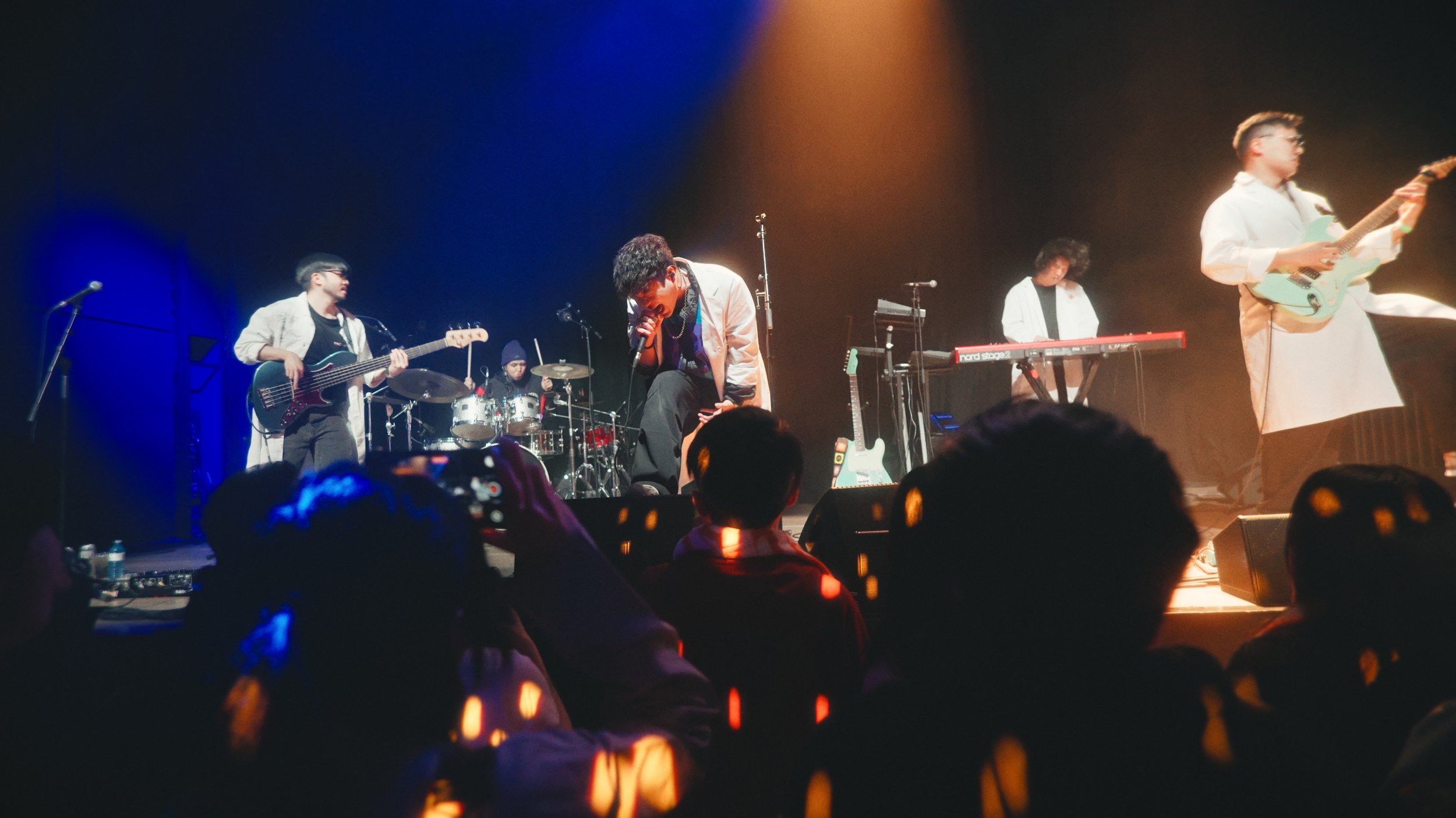 Band performing live on stage with audience in front, it's an example image of the concert event videography service