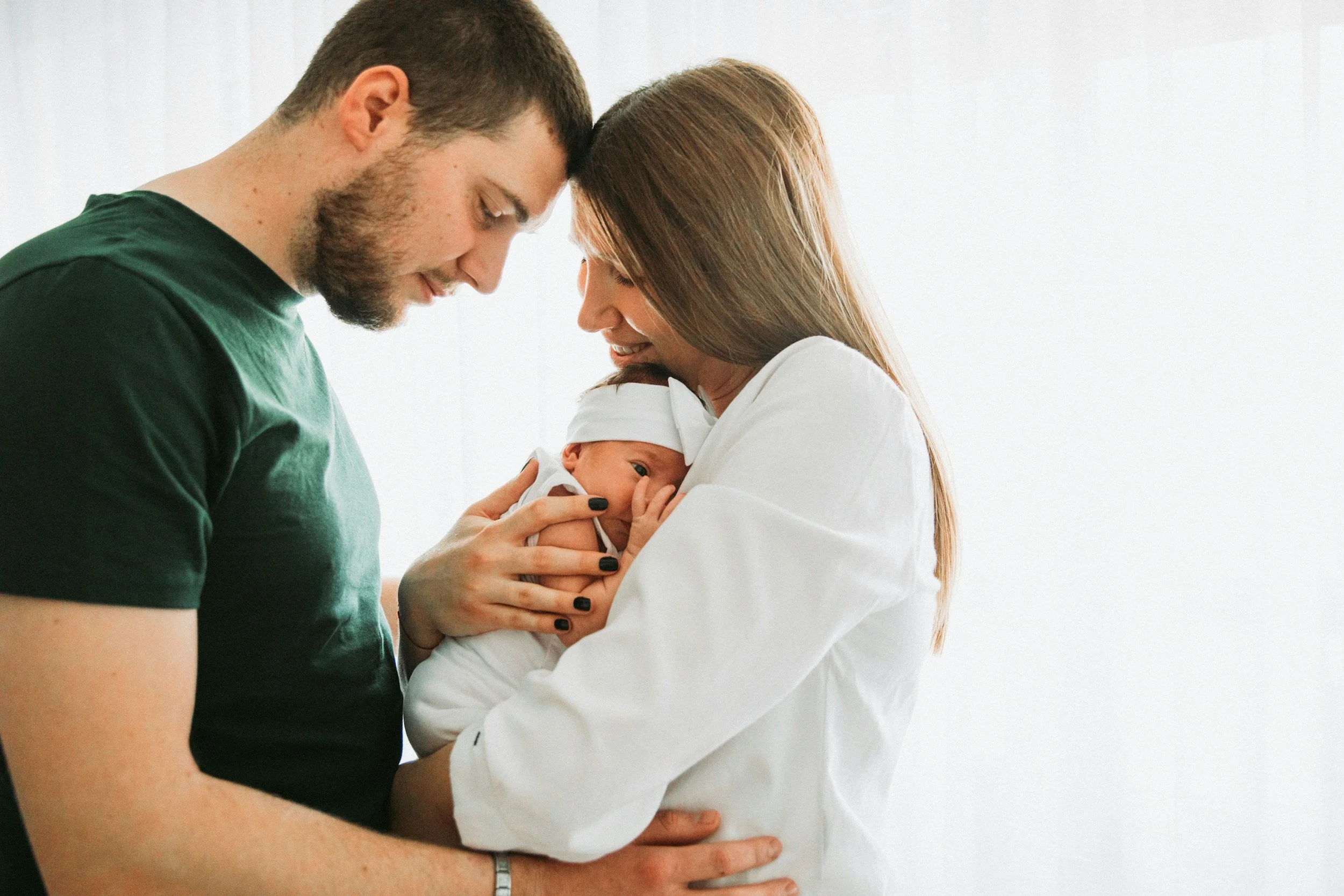 Postpartum therapy for women in Los Angeles, CA. Woman and her partner with baby. Woman is struggling with postpartum depression and seeking virtual therapy with Alexa Levine, LMFT.