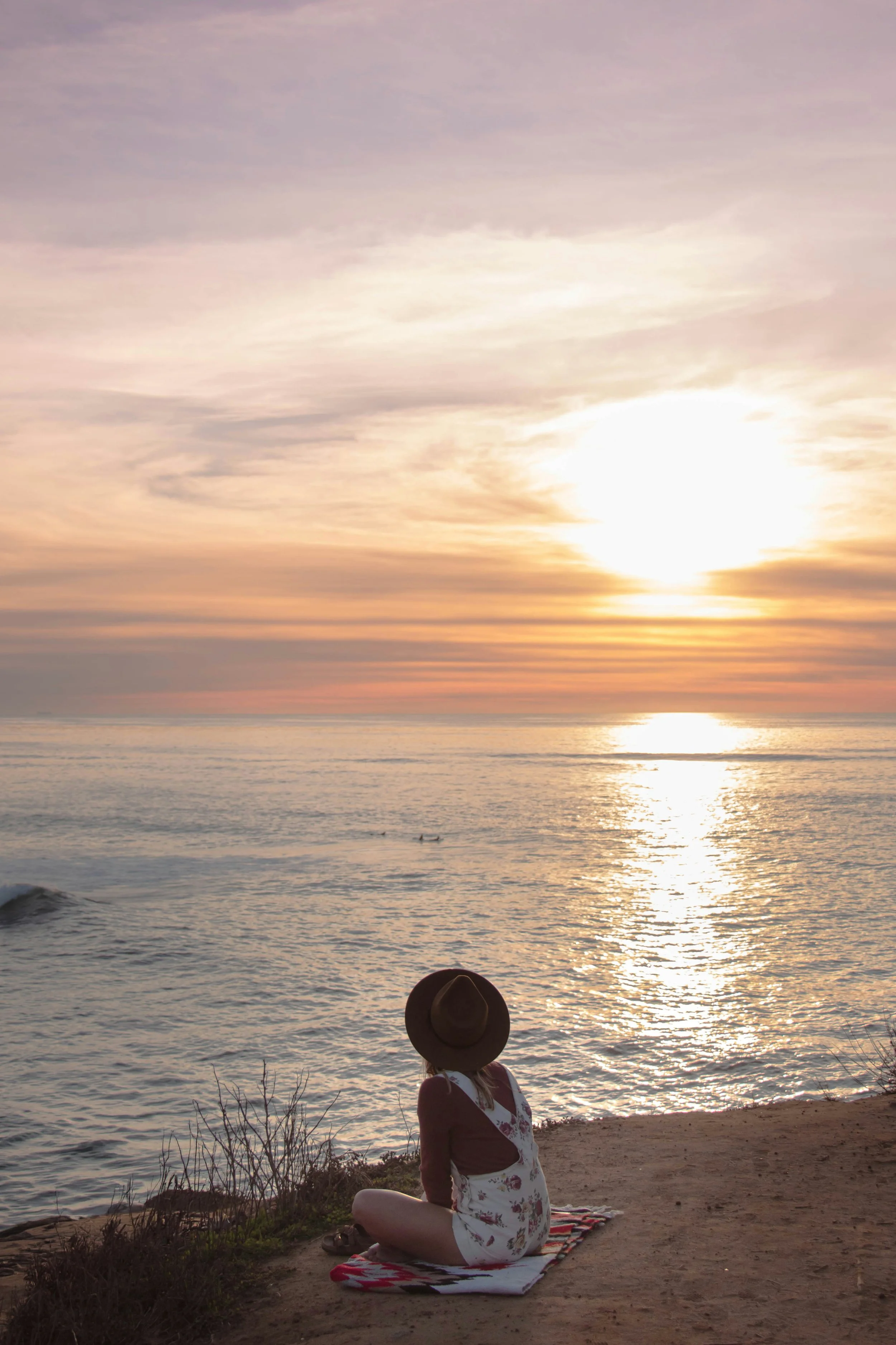 WOman sitting by the ocean in San Diego. Postpartum therapy for moms in San Diego County.