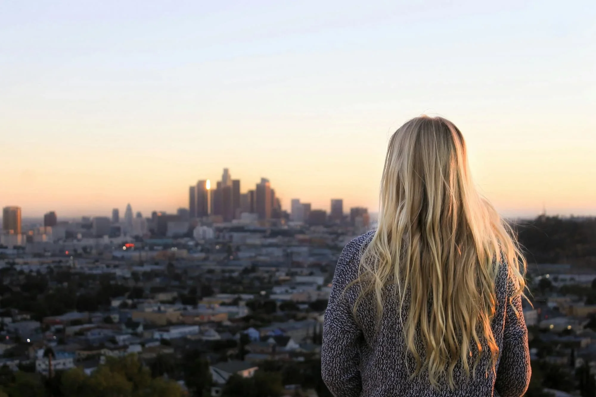 Postpartum Woman looking out at the Los Angeles skyline, virtual therapy for pregnancy, postpartum depression, and postpartum anxiety across Los Angeles and California.