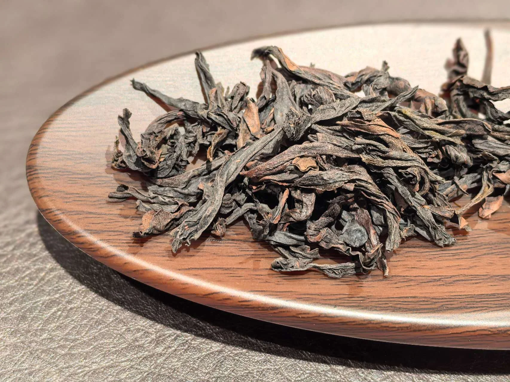 Dried tea leaves on a wooden plate.