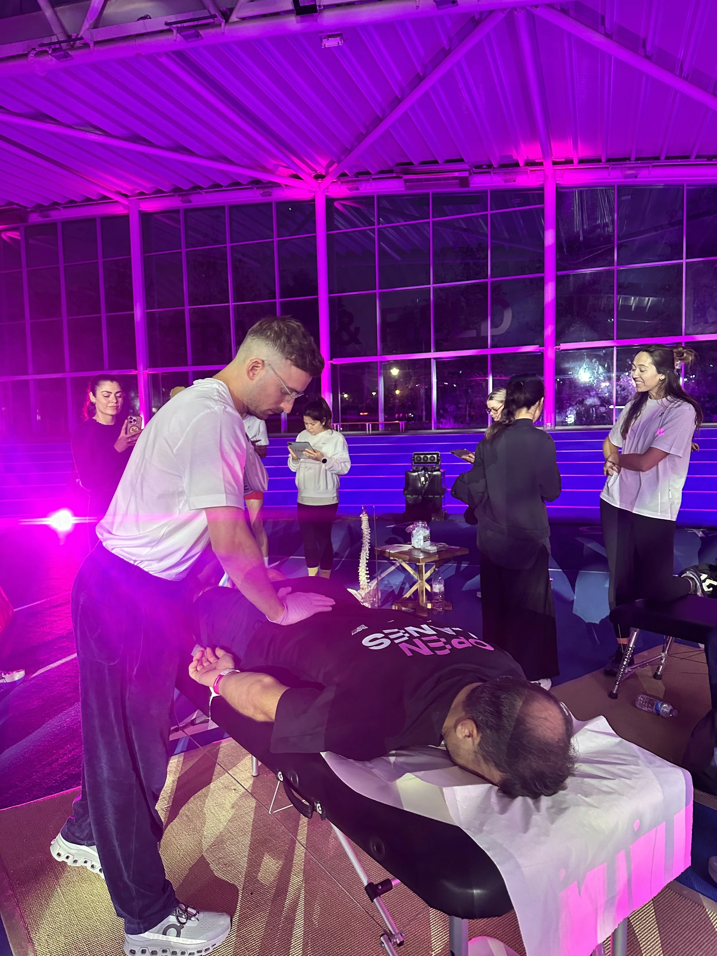 Max giving a sports massage at a running event helping athletes function better.
