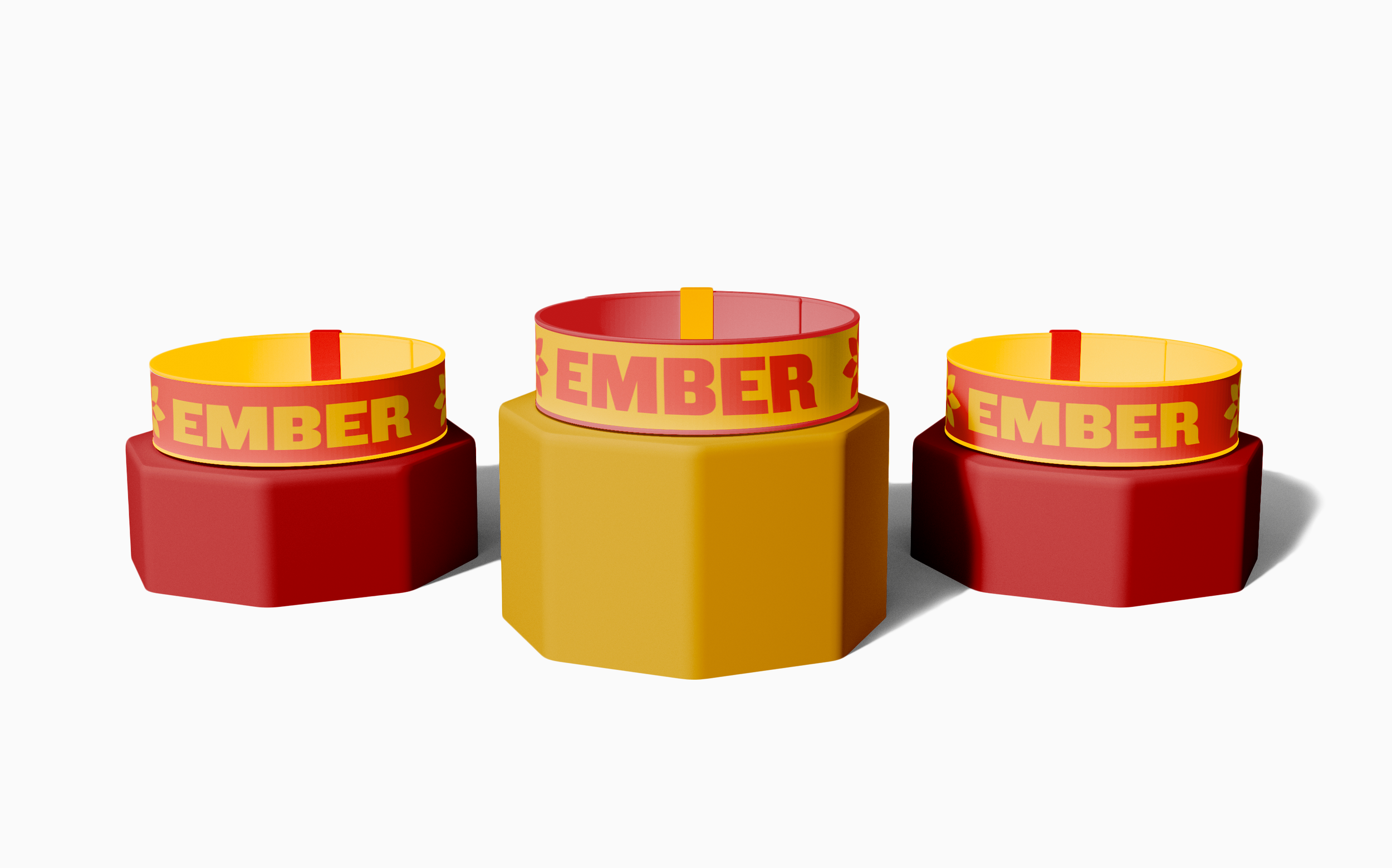 Three colorful cylindrical objects with the word 'EMBER' on yellow bands, placed on a white background. The objects are red, yellow, and red from left to right.