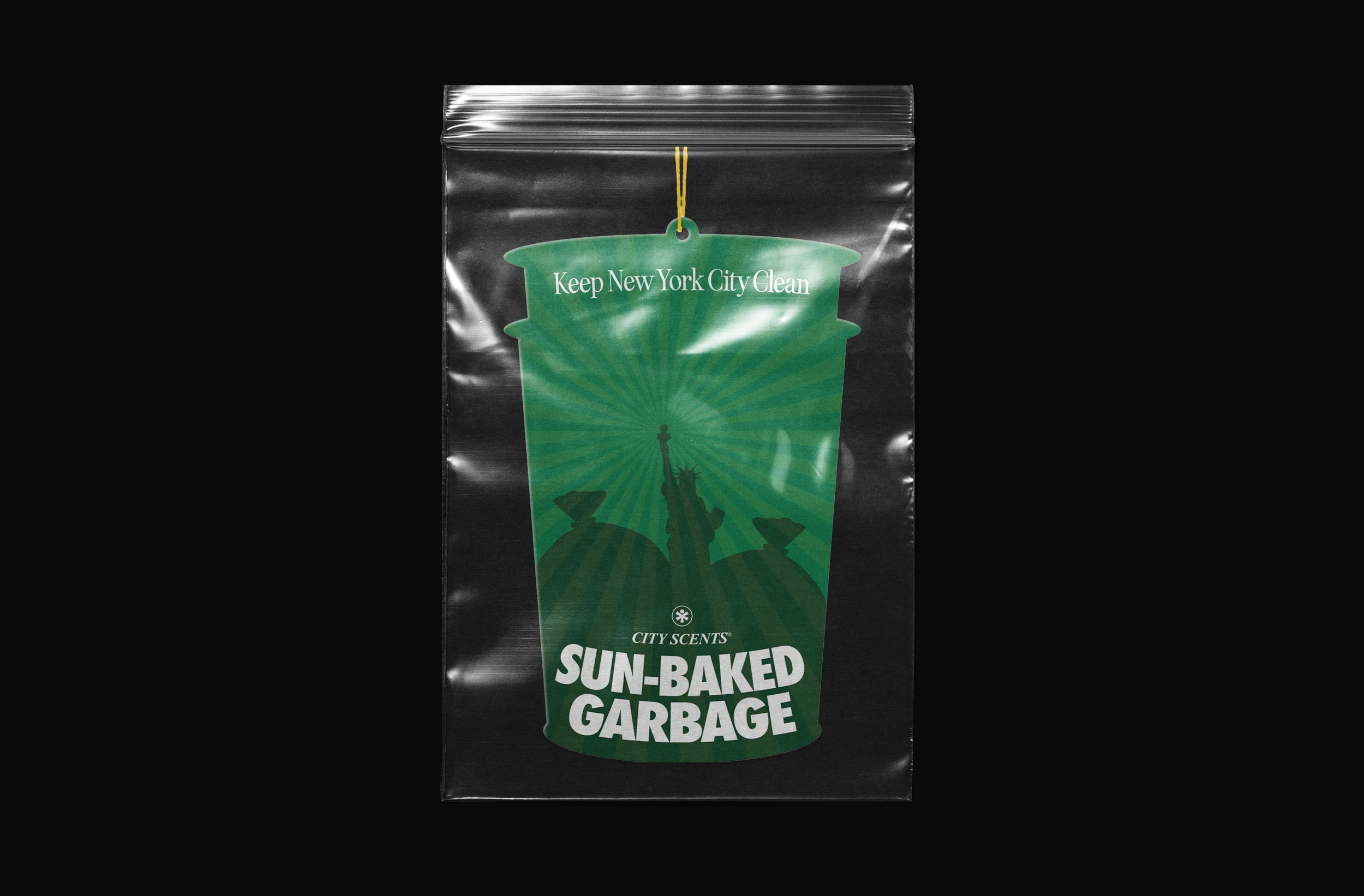 A black sealed plastic bag with a green label featuring a silhouette of the Statue of Liberty and Sun-Baked Garbage written on it.